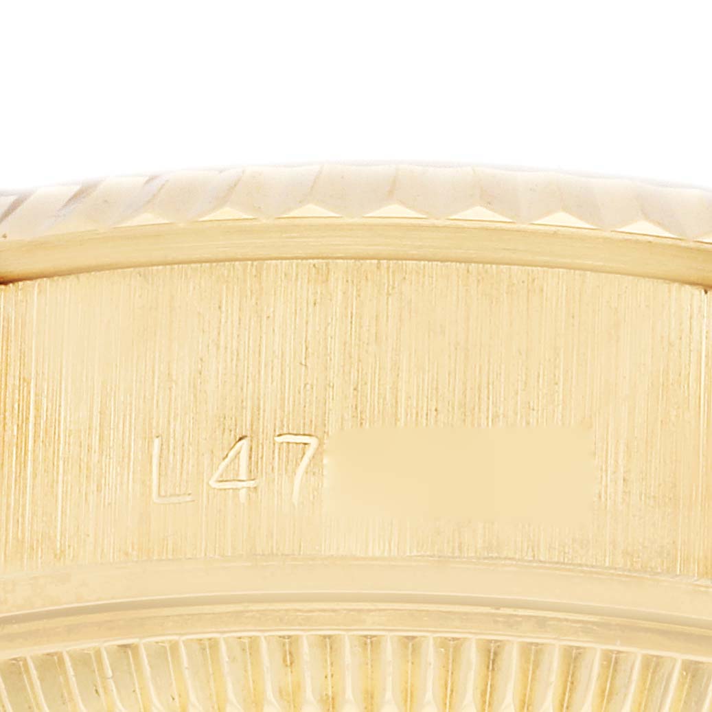 The image shows a close-up of the edge and engraved serial number on a Rolex President 69178 Women
s Yellow Gold Champagne Dial 69178 Women
s Yellow Gold Champagne Dial model, focusing on the watch case.