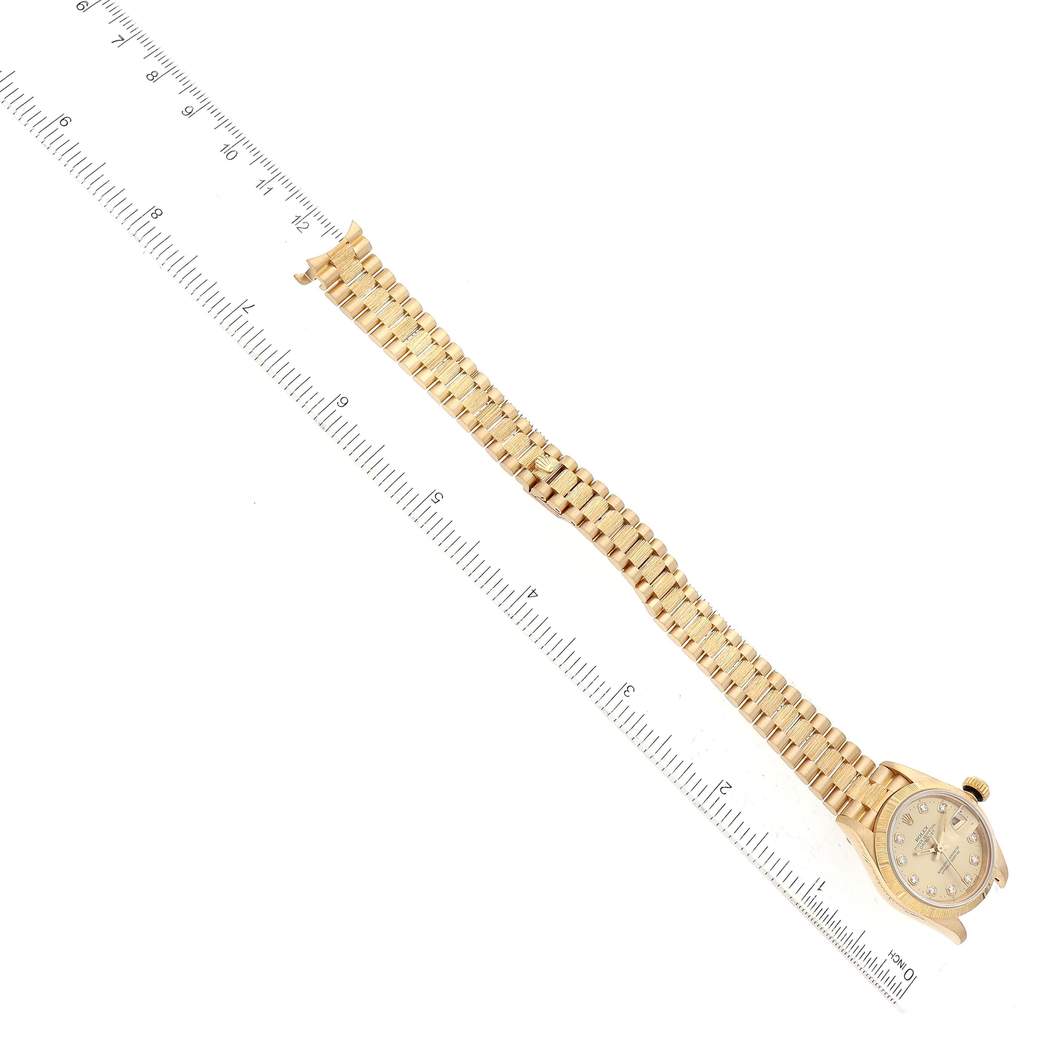The image shows a side view of a Rolex President 69278G Women's Yellow Gold Champagne Dial 69278G Women's Yellow Gold Champagne Dial model watch with its bracelet next to a ruler for scale.