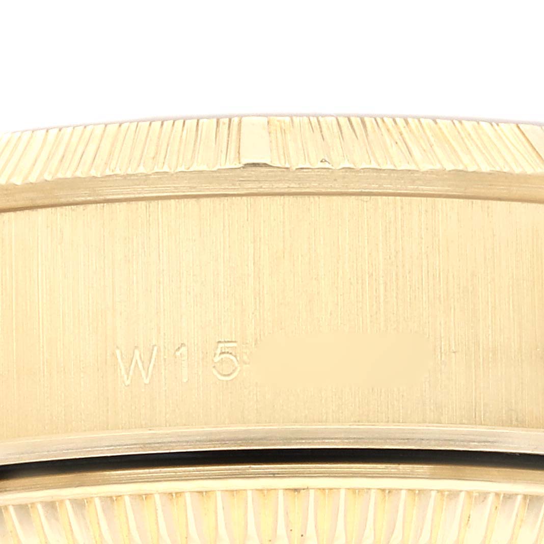 This close-up shows the engraved side of a Rolex President 69278G Women's Yellow Gold Champagne Dial 69278G Women's Yellow Gold Champagne Dial model watch, including part of its bezel and case.