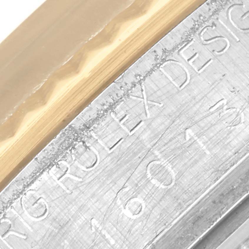 The image shows a close-up of the Rolex Datejust 16013 Men's Steel and Gold (two tone) Champagne Dial 16013 Men's Steel and Gold (two tone) Champagne Dial's rehaut and fluted bezel, featuring engraved text and model numbers.