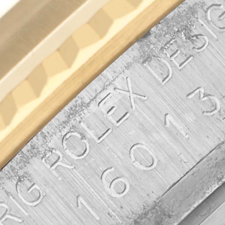 The image shows a close-up of the Rolex Datejust 16013 Men's Steel and Gold (two tone) Champagne Dial 16013 Men's Steel and Gold (two tone) Champagne Dial model's engraved inner bezel and a portion of the fluted bezel.