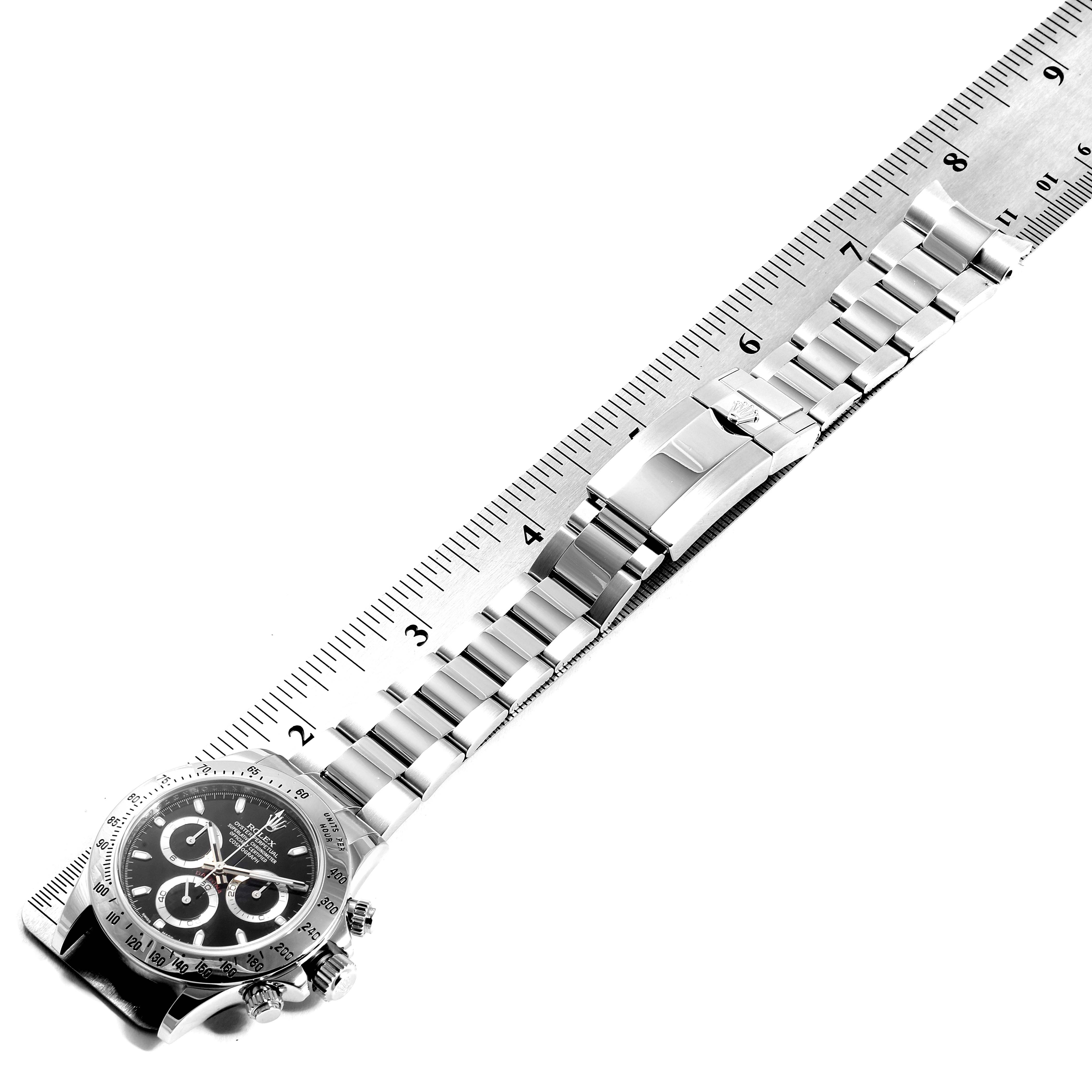 The image shows the full view of a Rolex Daytona 116520 Men's Stainless Steel Black Dial 116520 Men's Stainless Steel Black Dial watch and its metal bracelet, aligned with a ruler for measurement.
