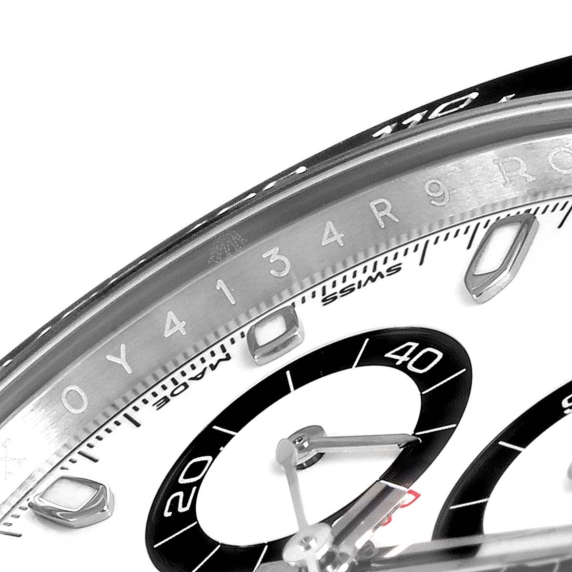 The image shows a close-up of the Rolex Daytona 116500 Men's Stainless Steel White Dial 116500 Men's Stainless Steel White Dial watch dial, bezel, and subdials at an oblique angle.