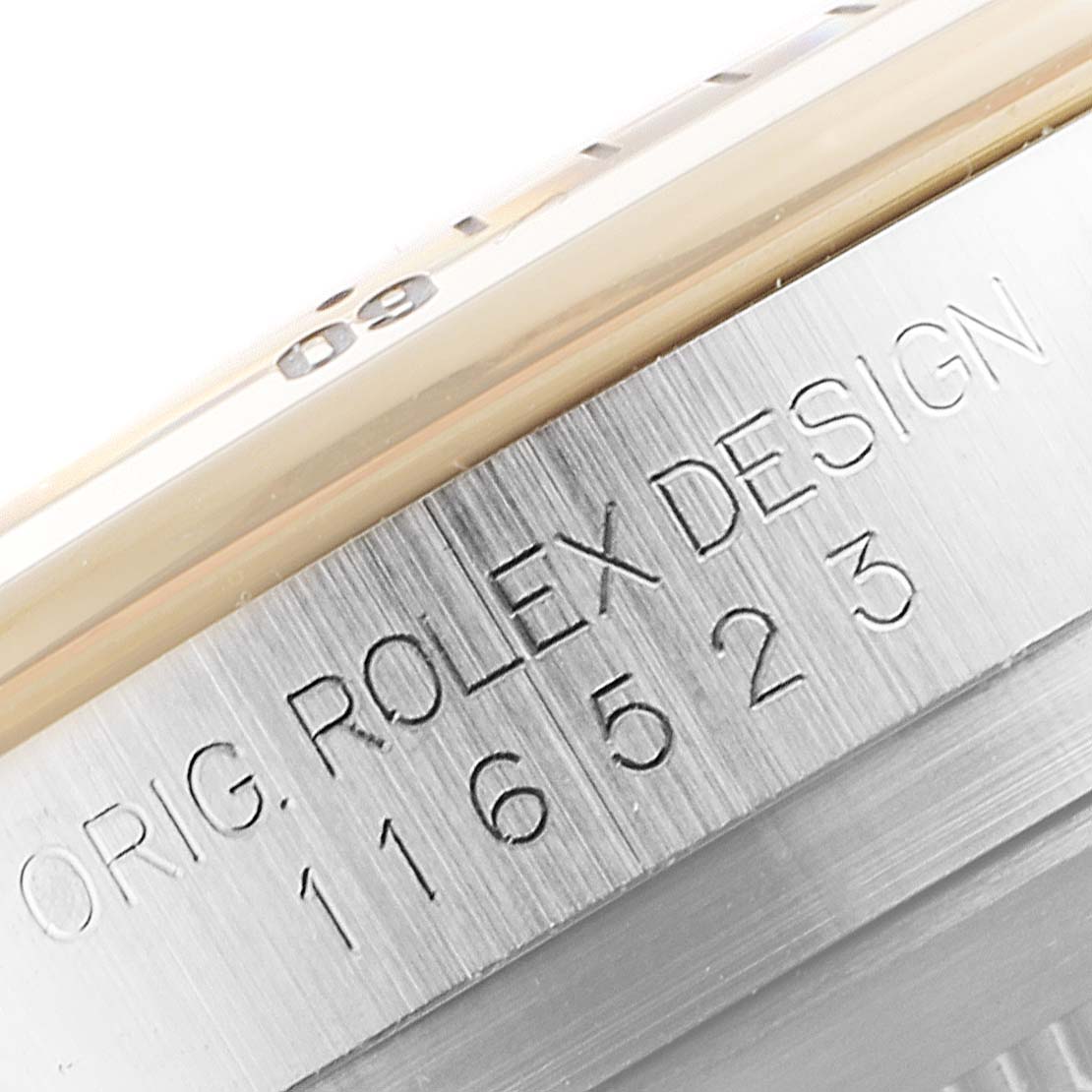 The image shows a close-up of the side of a Rolex Daytona 116523 Men's Steel and Gold (two tone) Mother of Pearl Dial 116523 Men's Steel and Gold (two tone) Mother of Pearl Dial watch, highlighting the bezel and engraving.