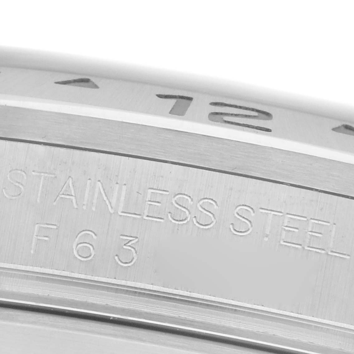 The image shows a close-up of the bezel and casing edge with "STAINLESS STEEL" engraved, from a Rolex Explorer 16570T Men's Stainless Steel Black Dial 16570T Men's Stainless Steel Black Dial watch.