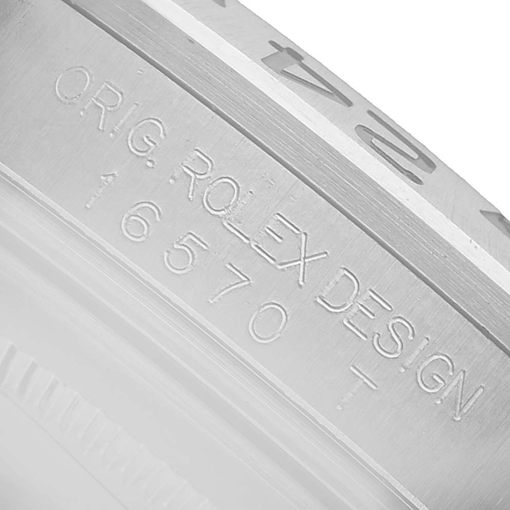 The image shows a close-up of the Rolex Explorer 16570T Men's Stainless Steel Black Dial model's bezel, featuring engraved model details.