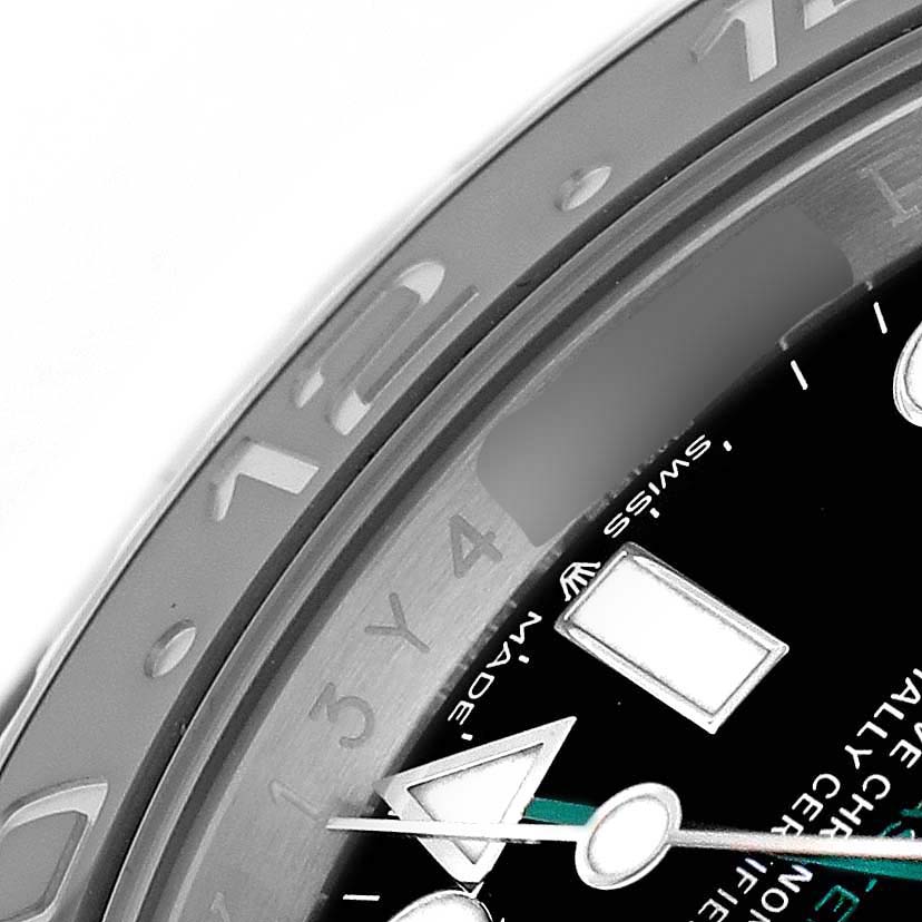 The image shows a close-up of the Rolex GMT-Master 126710GRNR Men's Stainless Steel Black Dial's bezel and part of the dial, displaying hour markers and hands.