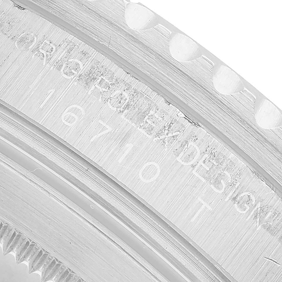 The close-up image shows the side of the bezel and engraved details of a Rolex GMT-Master 16710 Men's Stainless Steel Black Dial, highlighting its design elements.