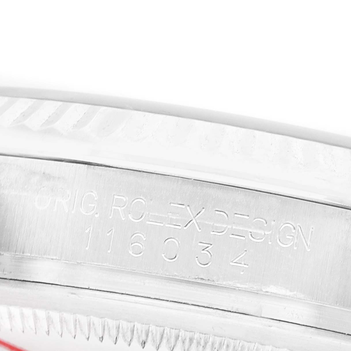 The image shows a close-up of the case side engraving on a Rolex Oyster Perpetual 116034 Men's Stainless Steel Black Dial, displaying the model and design numbers.