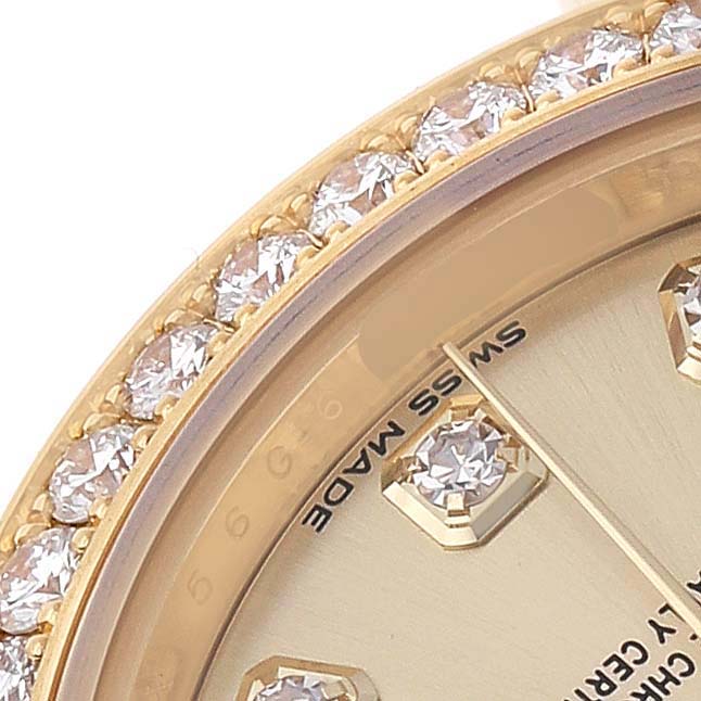 The image shows a close-up of the gold bezel with diamonds and part of the champagne dial of the Rolex President 279138 Women's Yellow Gold Champagne Dial watch.