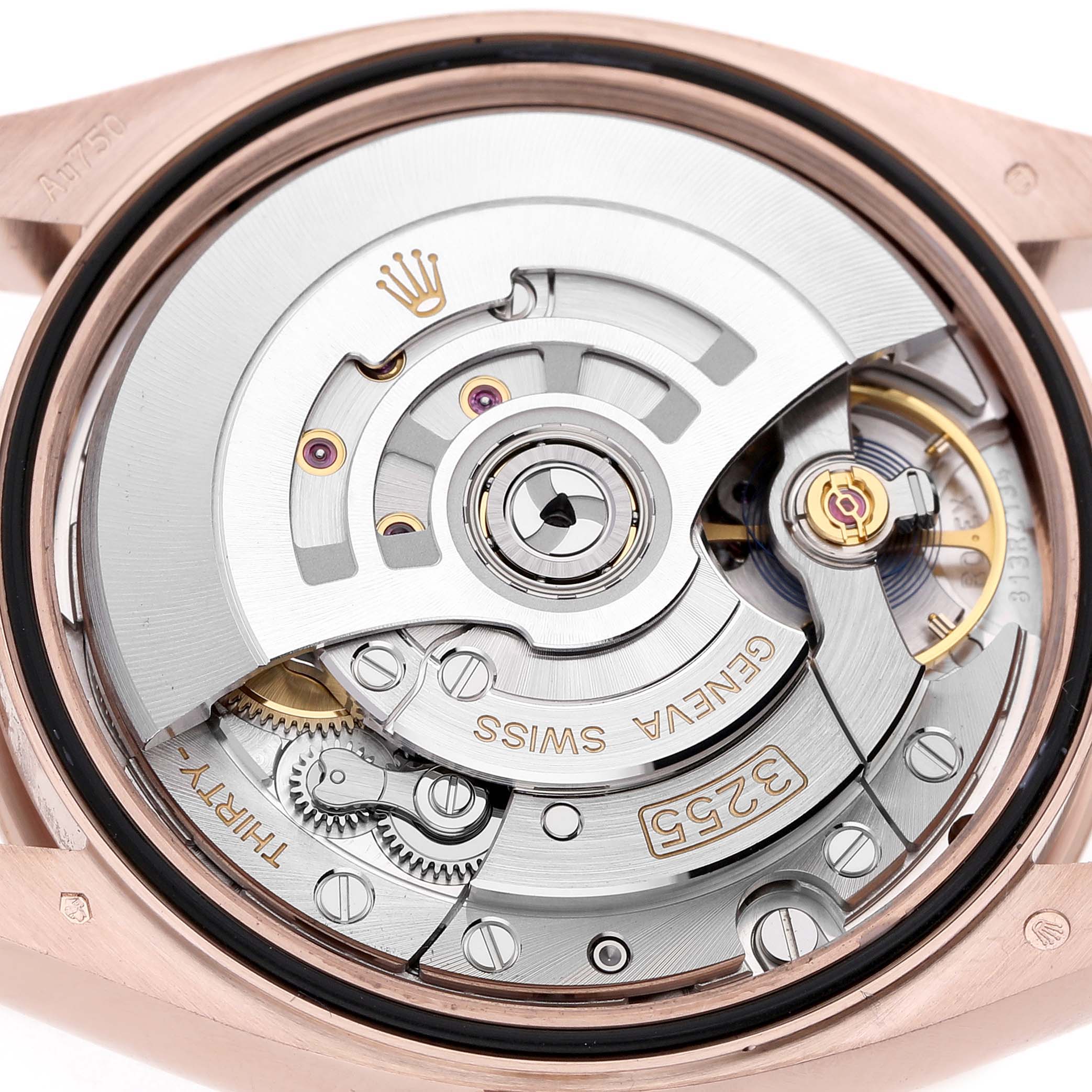 The image shows the movement of a Rolex President 128235 Men's Rose Gold Brown Dial model from the back, highlighting the intricate gears and rotor.