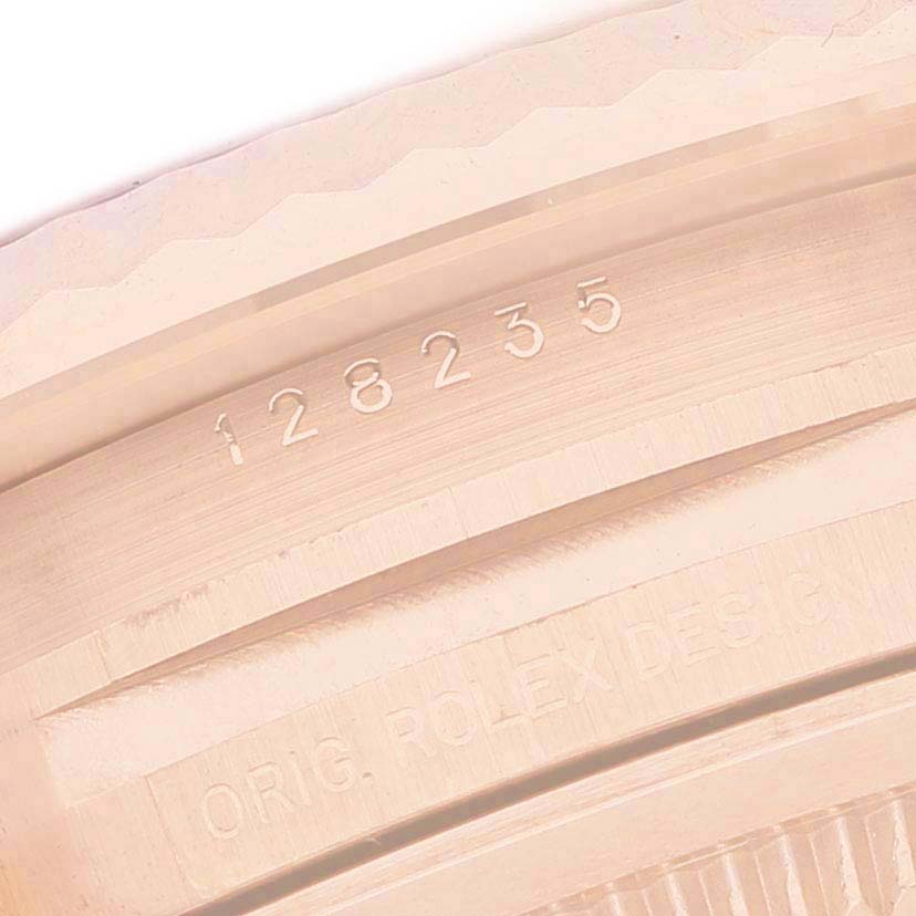 The image shows a close-up of the engraved side of a Rolex President 128235 Men's Rose Gold Brown Dial model, displaying the model number and "Orig. Rolex Design."