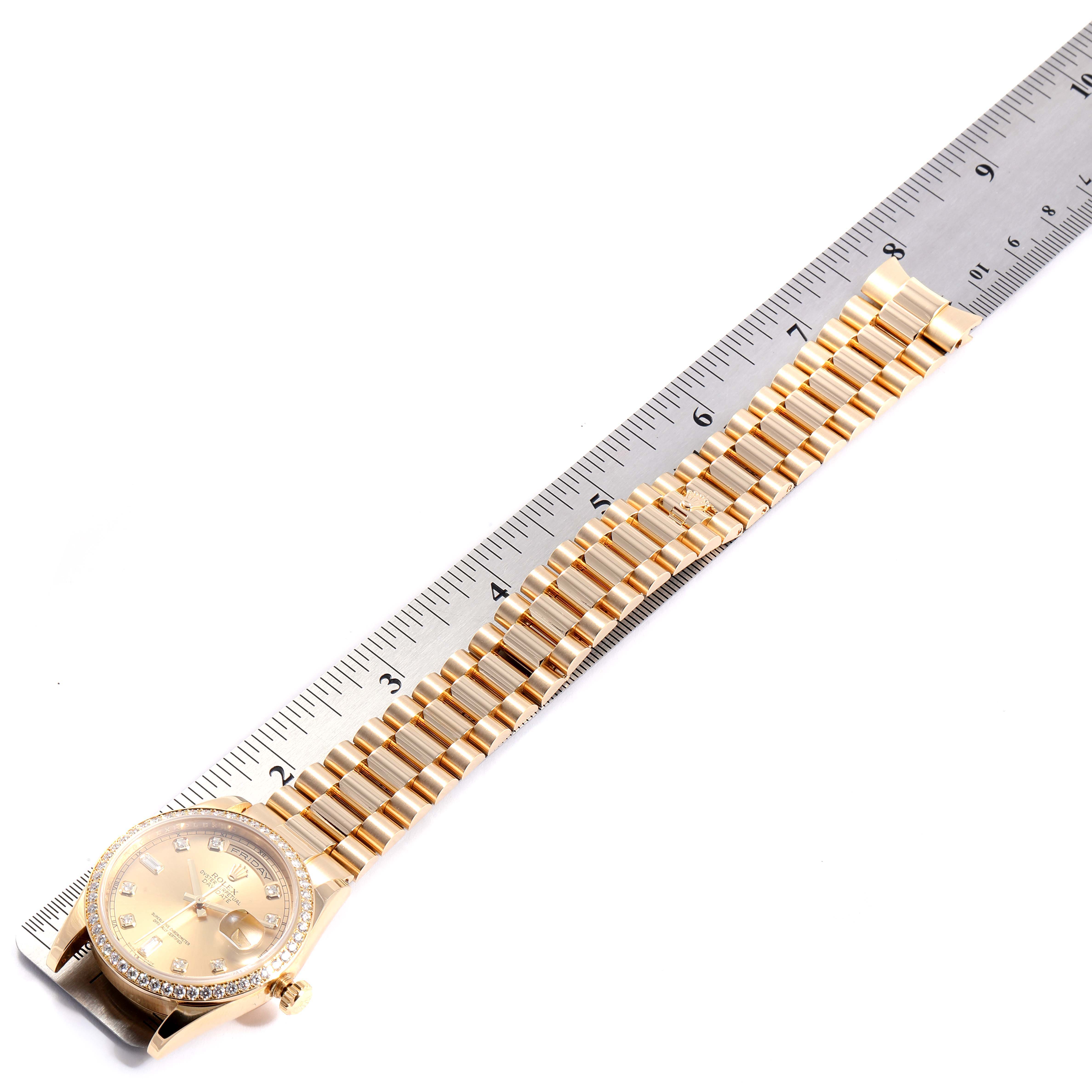 The Rolex President 118348 Men
s Yellow Gold Mother of Pearl Dial 118348 Men
s Yellow Gold Mother of Pearl Dial model watch is shown at a side angle with an extended gold bracelet beside a ruler.