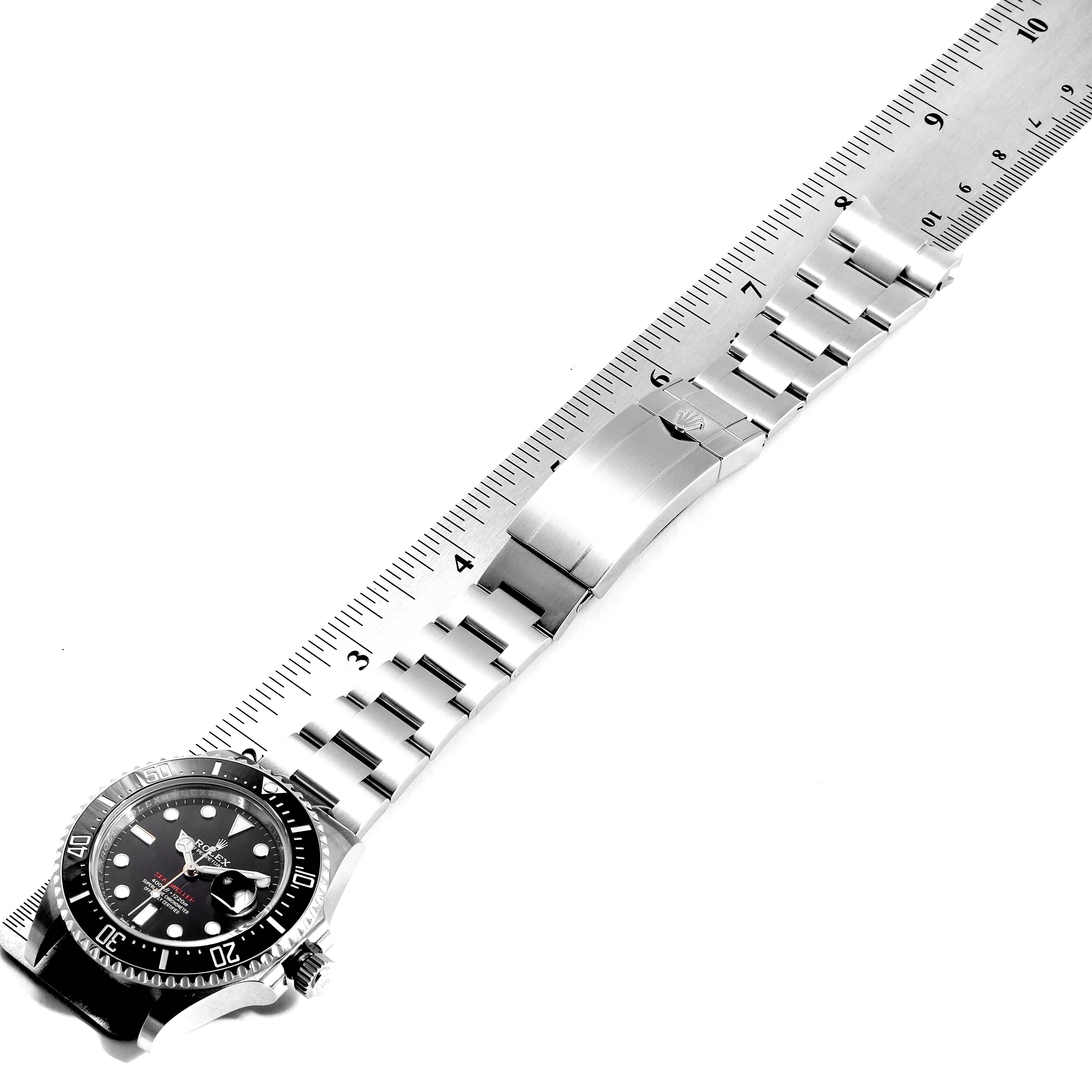 The image shows a Sea-Dweller Rolex watch laid flat with a metal band measured against a ruler.