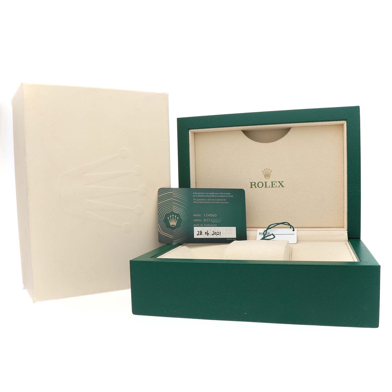The image shows the packaging and accessories for a Rolex Submariner M124060-0001 Men's Stainless Steel Black Dial, including a green box, warranty card, and tag.