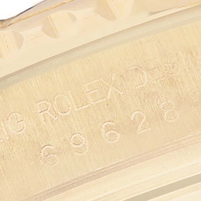 This close-up image shows the engraved serial number and part of the bezel of a Rolex Yacht-Master 69628 Women's Yellow Gold Blue Dial 69628 Women's Yellow Gold Blue Dial watch.