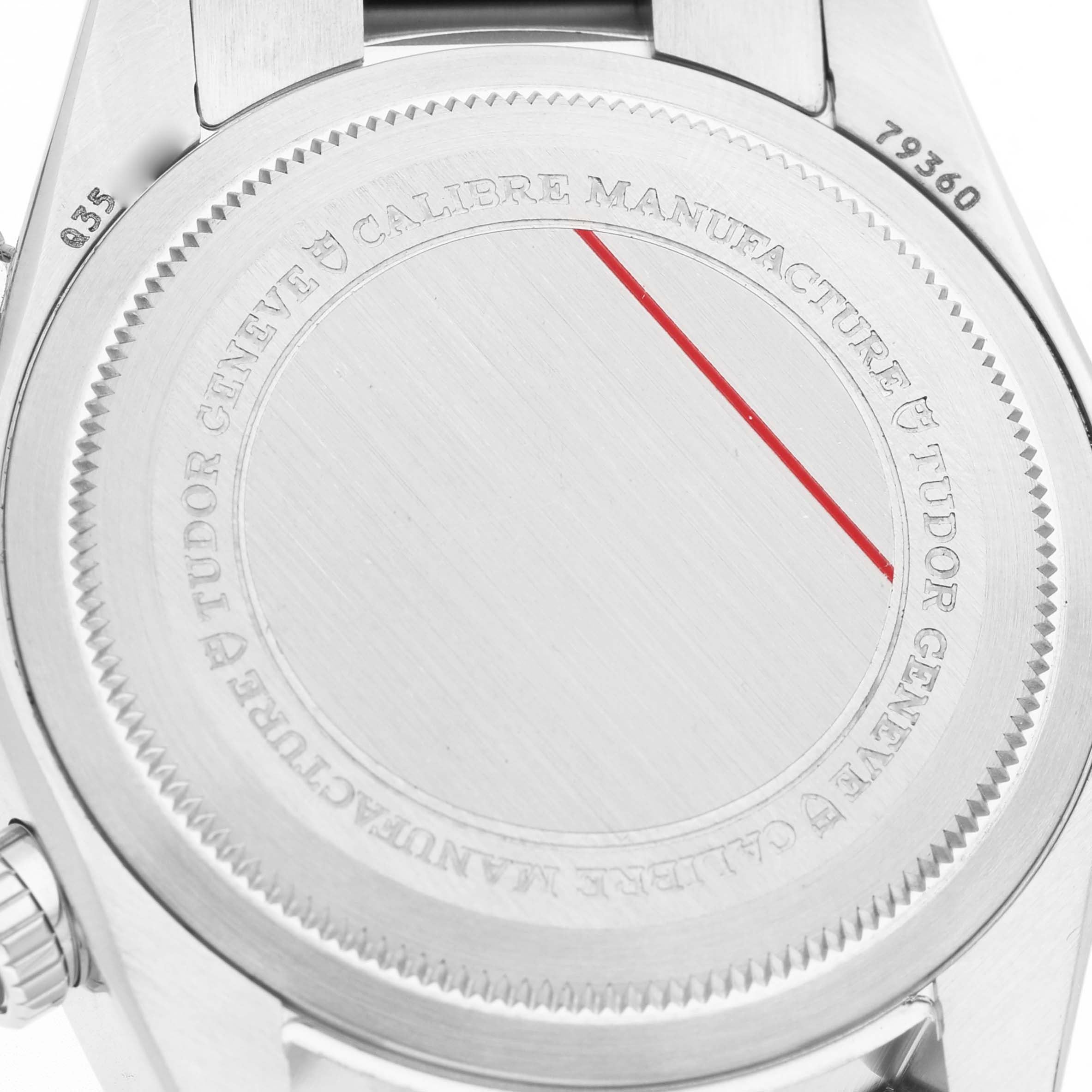 The image shows the case back of a Tudor Heritage Chrono 79360N-0001 Men's Stainless Steel Black Dial watch with engraved details and a partial bracelet view.