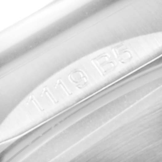 This image shows a close-up of the edge of a Breitling Navitimer watch, focusing on a serial or model number "1119 B5."