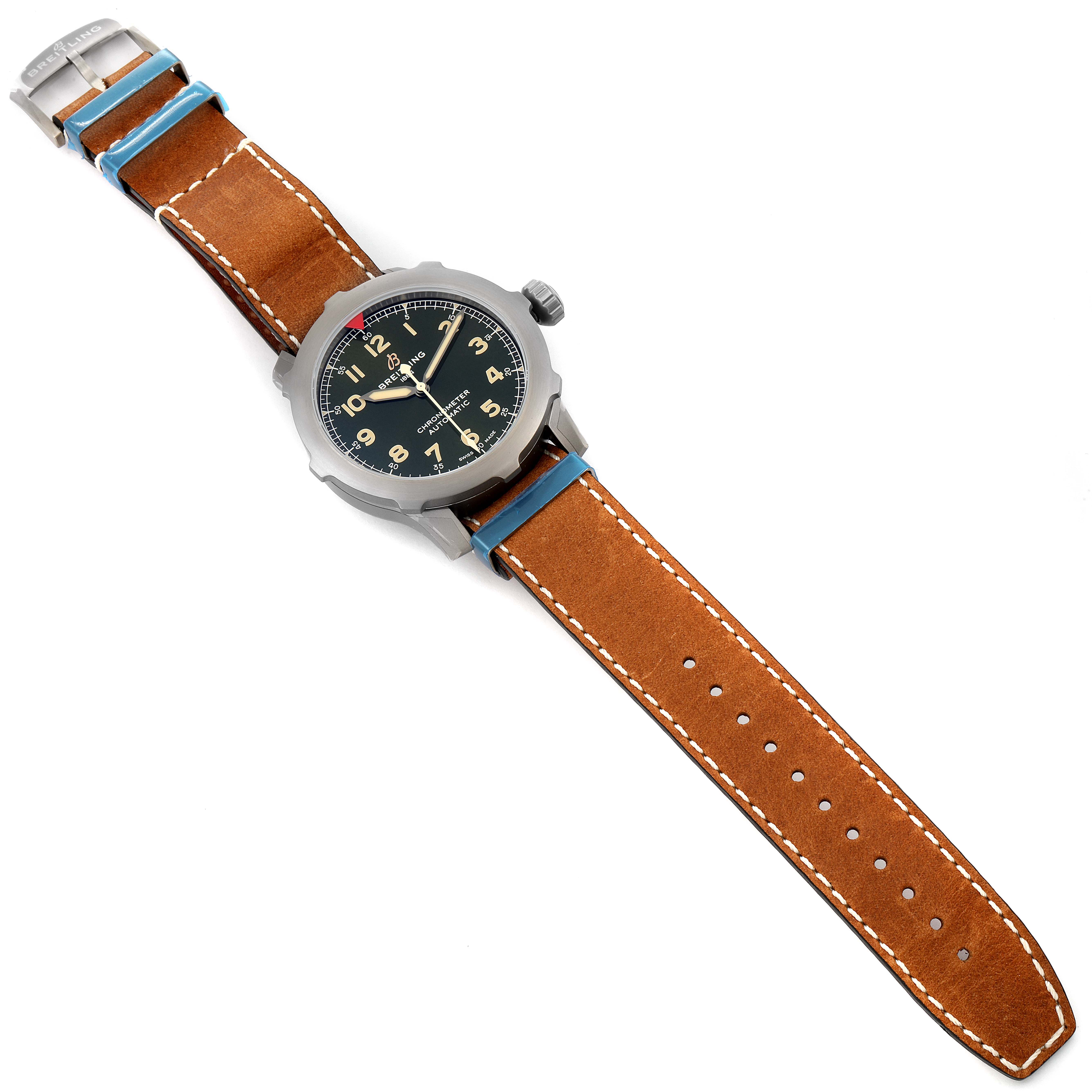 The image shows a top-down view of a Breitling Navitimer watch, highlighting its brown leather strap and black dial.