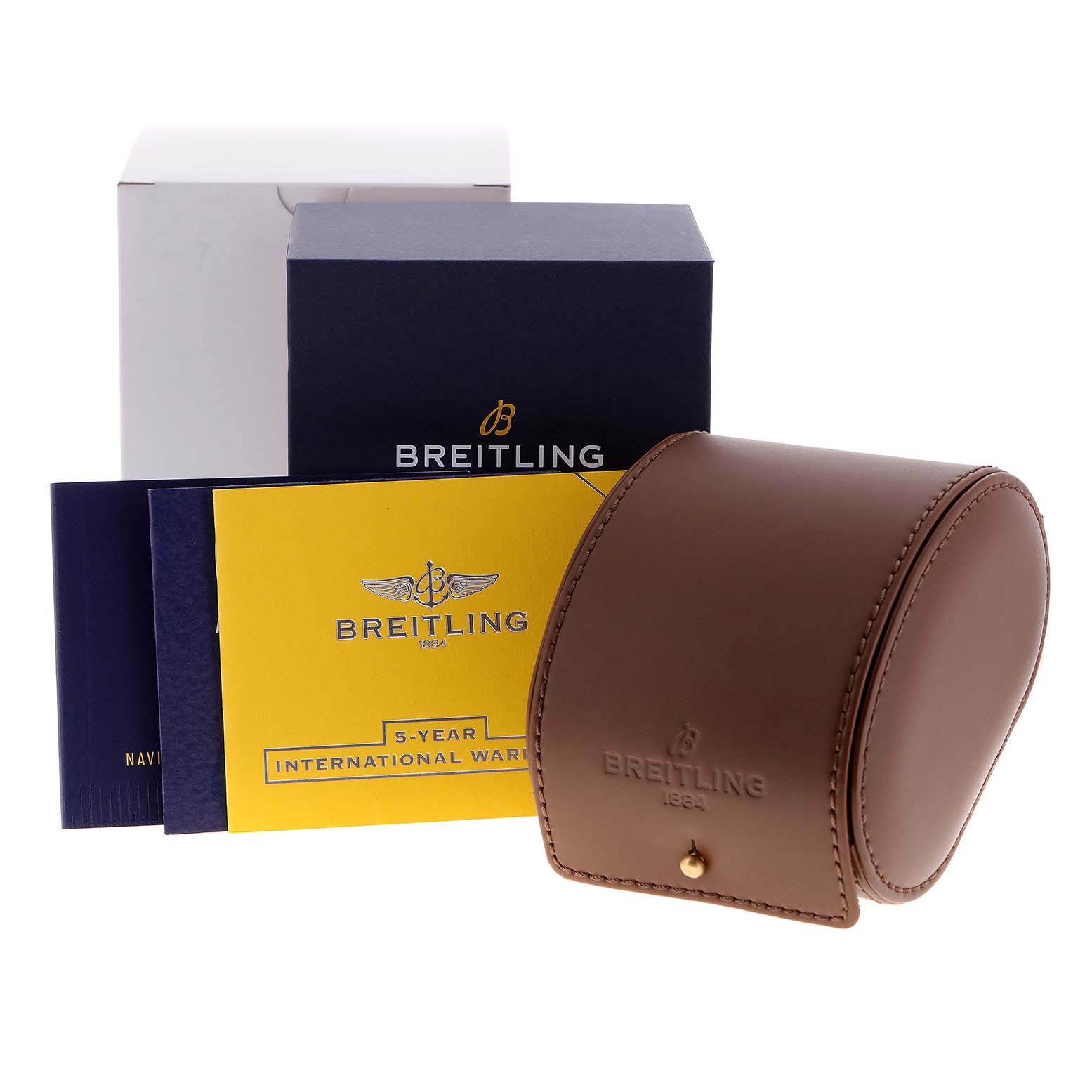 The image shows Breitling Navitimer watch accessories, including boxes, a brown leather case, and warranty cards.