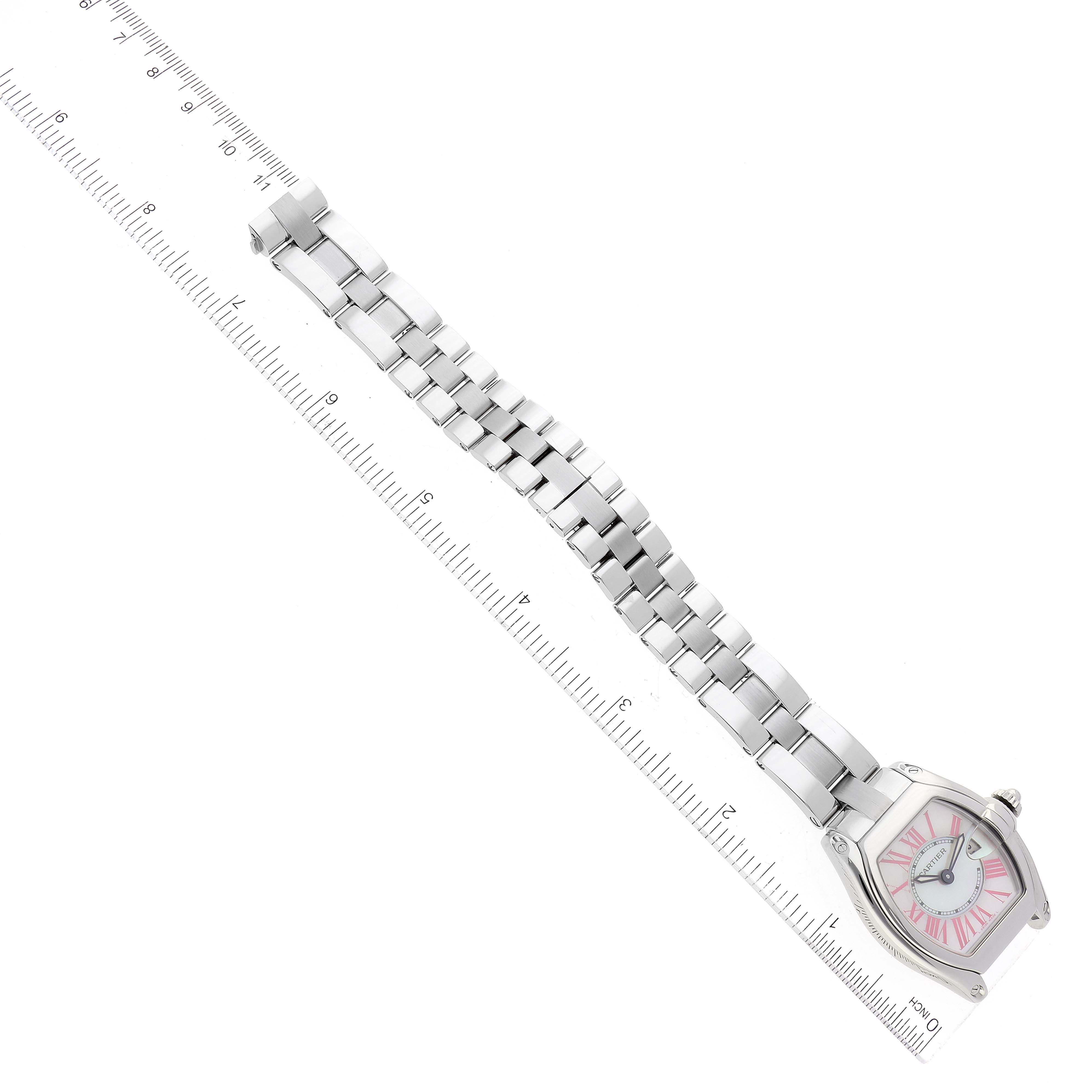 The image shows a Cartier Roadster W6206006 Women's Stainless Steel Mother of Pearl Dial W6206006 Women's Stainless Steel Mother of Pearl Dial watch placed alongside a ruler, displaying its metal bracelet and the watch face at an angle.