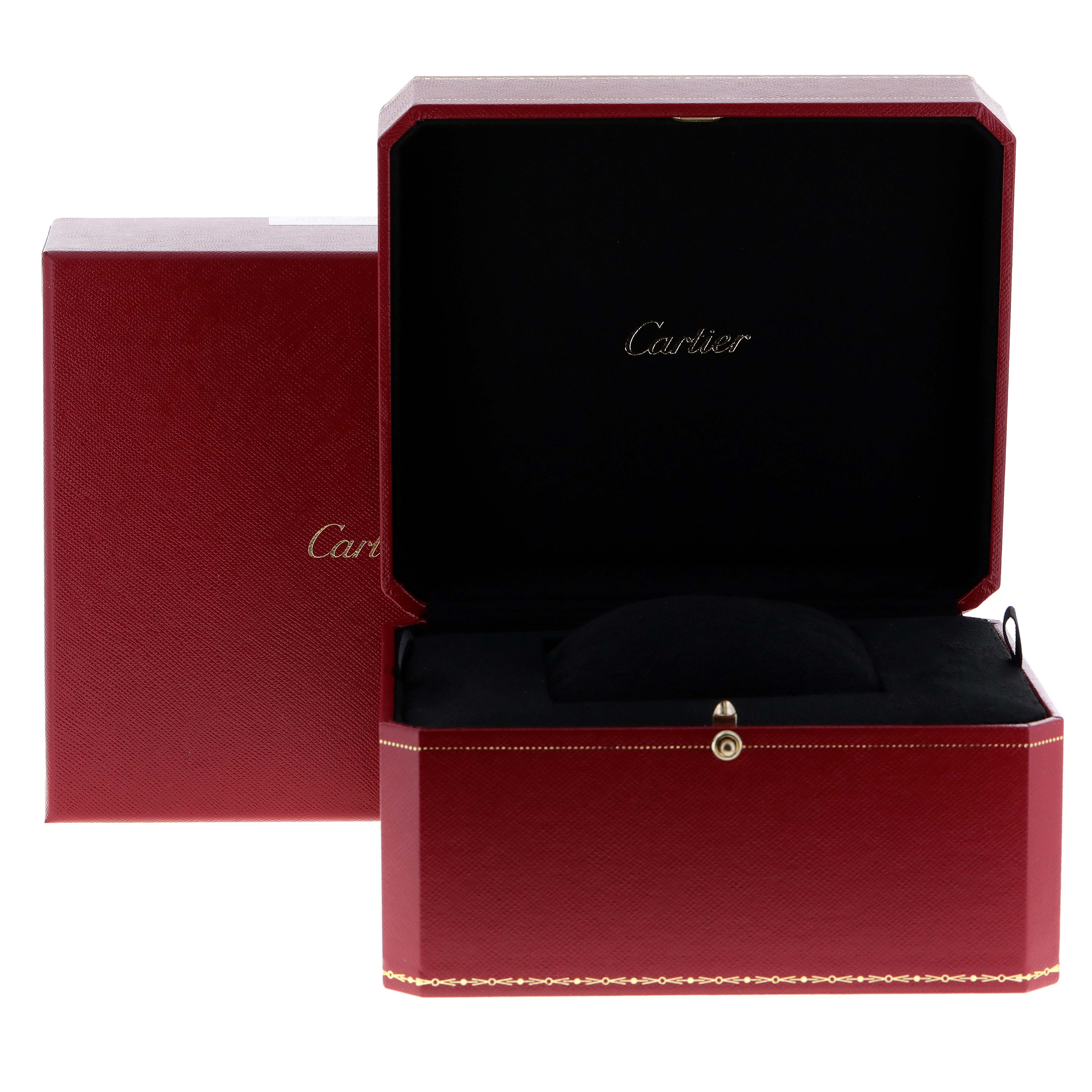 A Cartier Tank Française box is open, revealing its interior with a black cushion for the watch.