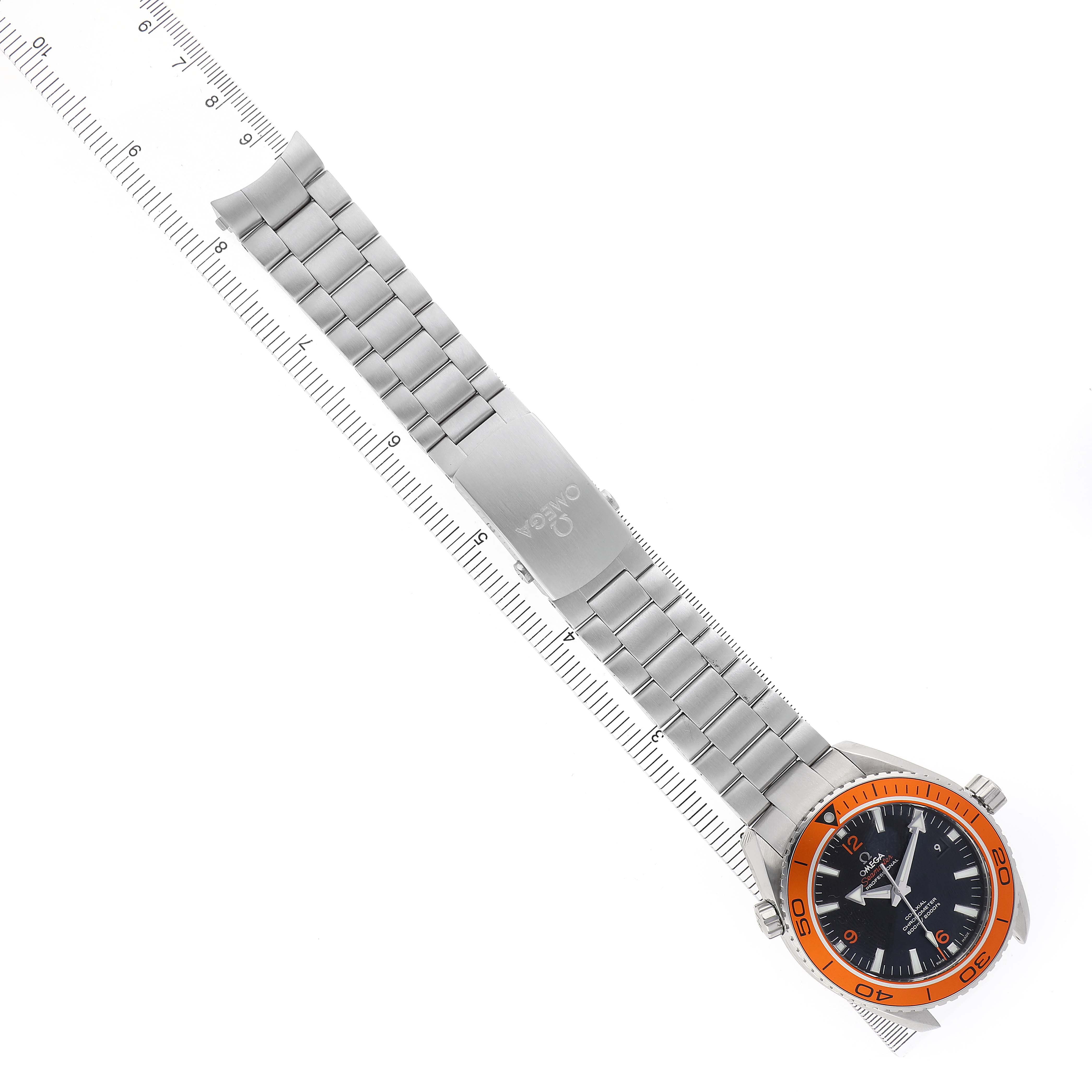 The Omega Planet Ocean 232.30.46.21.01.002 Men's Stainless Steel Black Dial watch is shown from an overhead angle, highlighting its orange bezel, metal bracelet, and clasp.