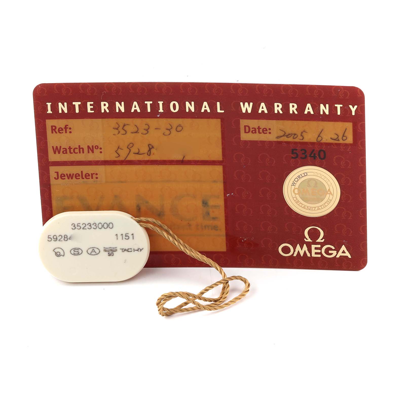 The image shows an Omega Speedmaster 3523.30.00 Men's Stainless Steel Silver Dial 3523.30.00 Men's Stainless Steel Silver Dial international warranty card and a tag with reference numbers.