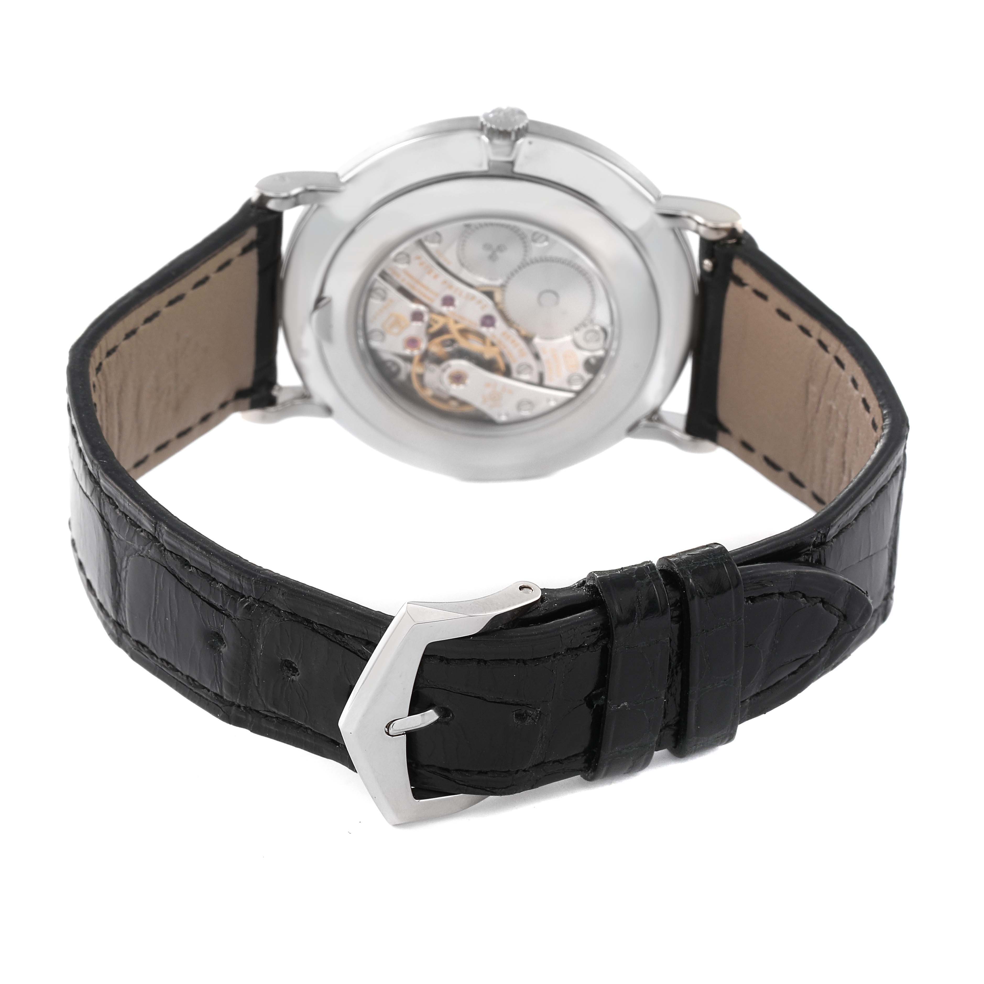 The image shows a rear view of a Patek Philippe Calatrava 5119G Men
s White Gold White Dial 5119G Men
s White Gold White Dial watch with visible movement and a black leather strap.