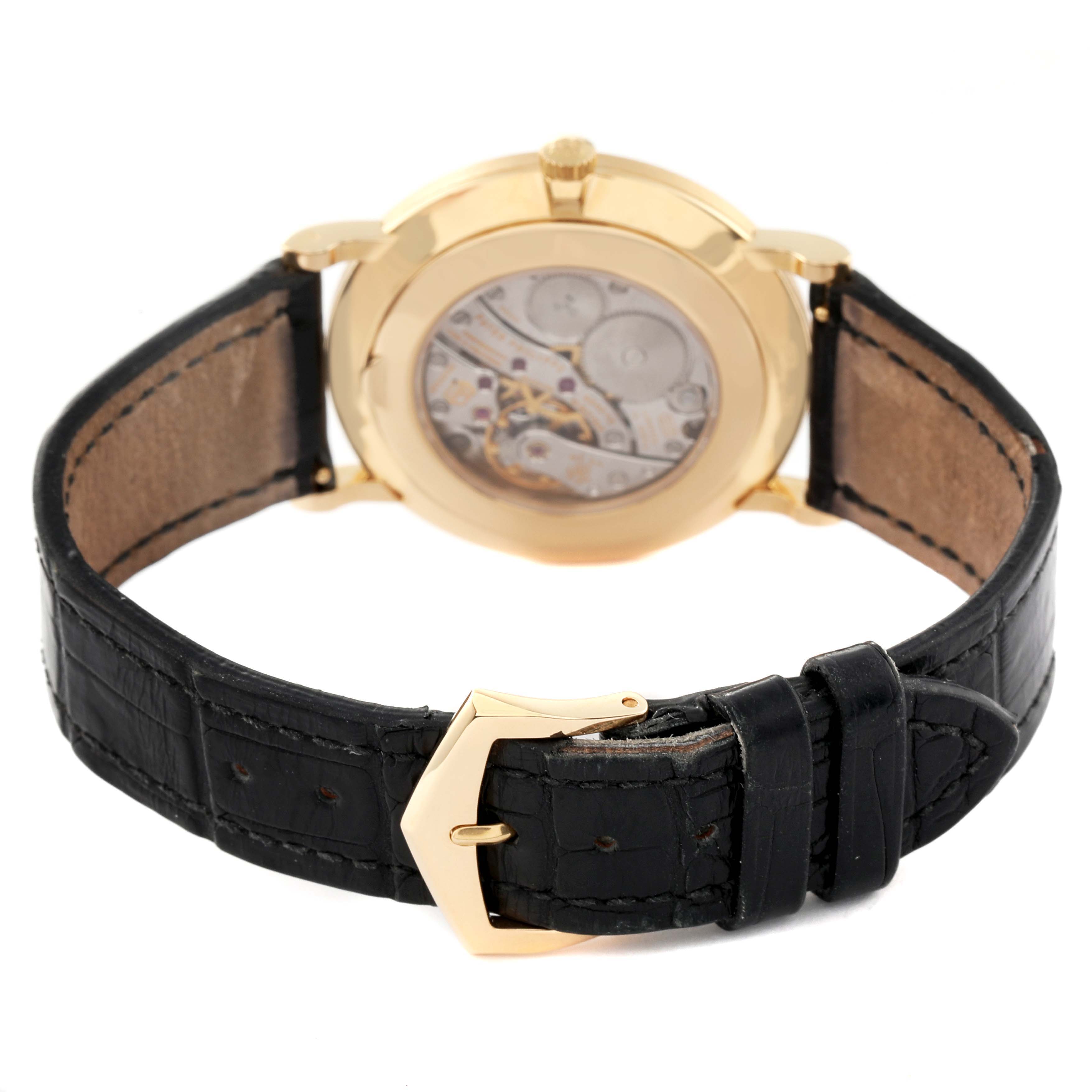 The image shows the back view of a Patek Philippe Calatrava 5119J Men
s White Gold White Dial 5119J Men
s White Gold White Dial watch highlighting its movement and black leather strap with gold buckle.