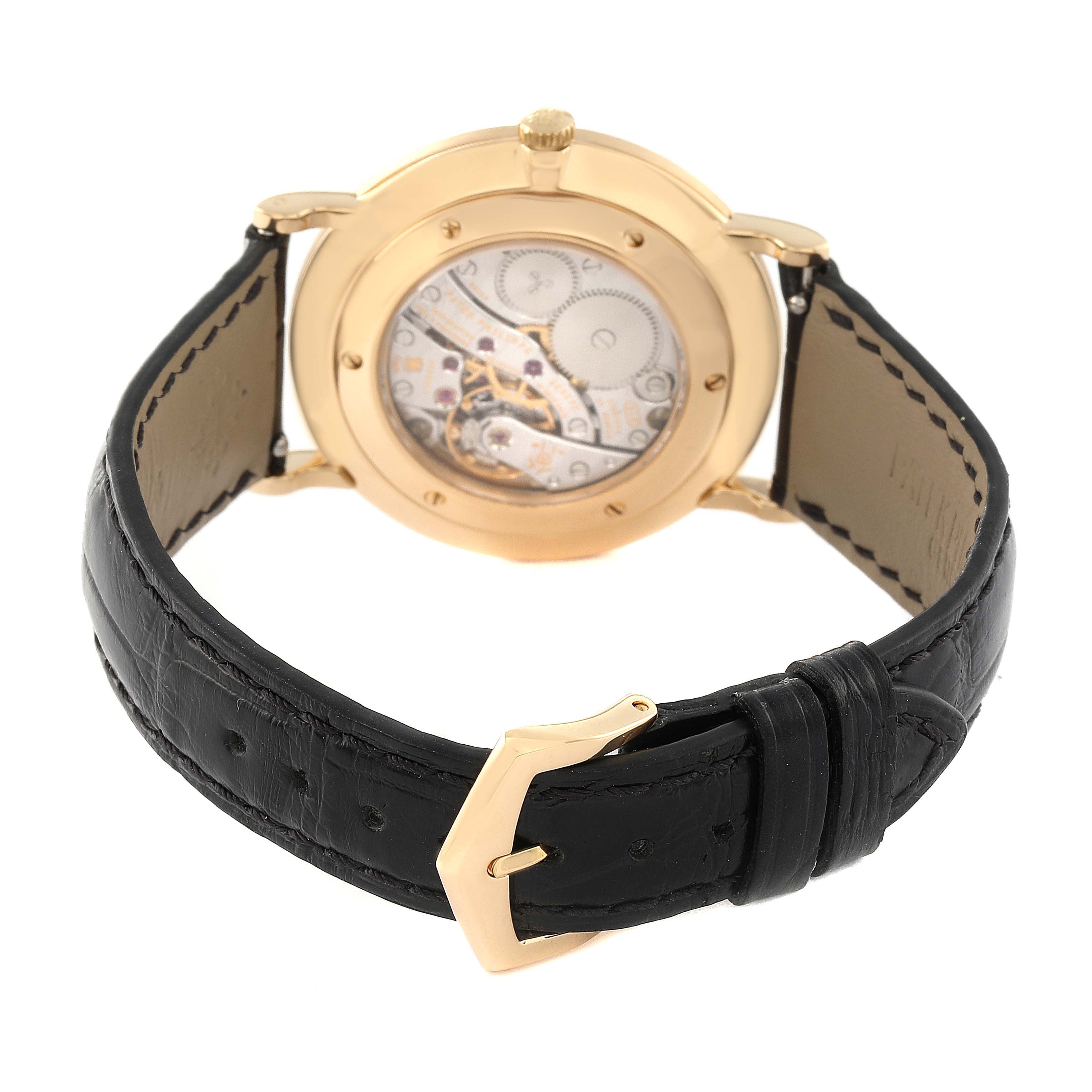 The image shows the back view of a Patek Philippe Calatrava 5119J Men's Yellow Gold White Dial 5119J Men's Yellow Gold White Dial watch, highlighting the transparent case back and black leather strap.