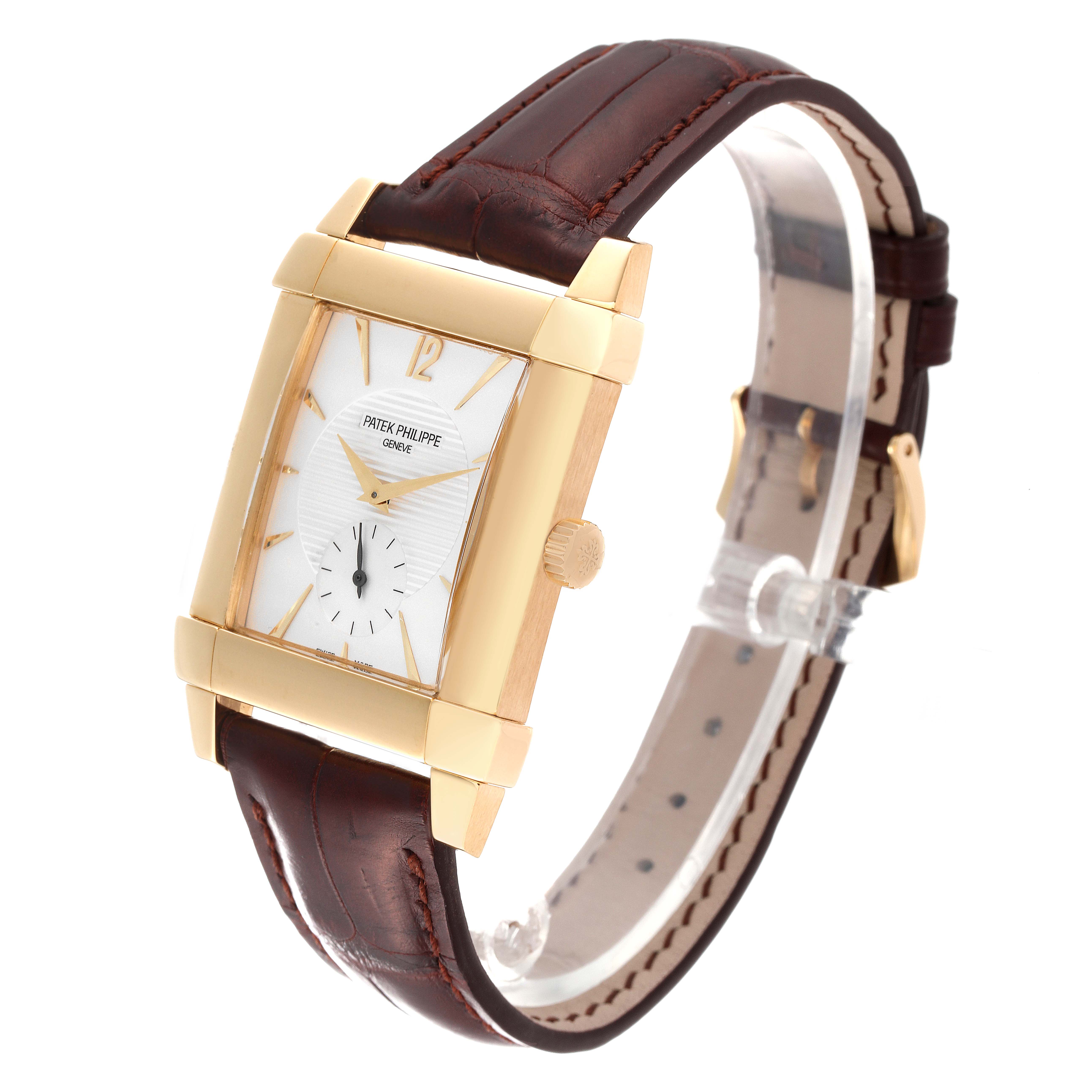 The Patek Philippe Gondolo 5111J Men's Yellow Gold Silver Dial 5111J Men's Yellow Gold Silver Dial watch is shown at a front-side angle, displaying its gold case, white dial, crown, and brown leather strap.