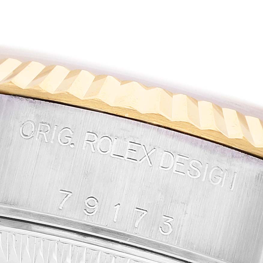 The image shows a close-up of the case edge on a Rolex Datejust 79173 Women's Steel and Gold (two tone) Silver Dial, highlighting the fluted bezel and engraved model number.