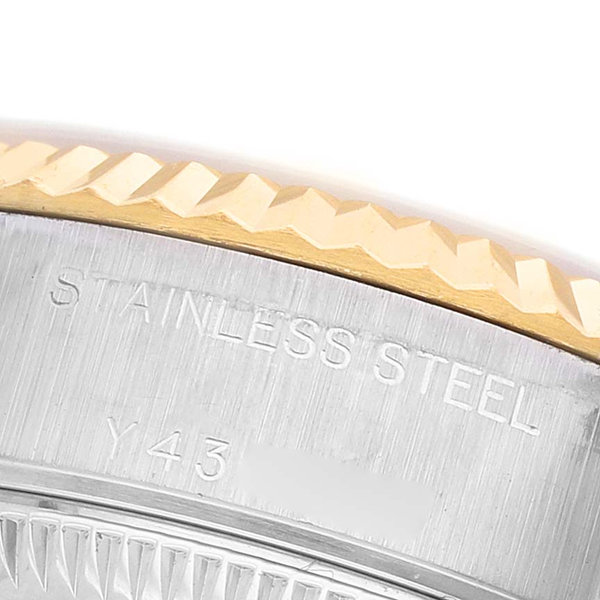 The image shows a close-up of the fluted bezel and edge of the case back of a Rolex Datejust 79173 Women's Steel and Gold (two tone) Silver Dial, highlighting the "Stainless Steel" engraving.