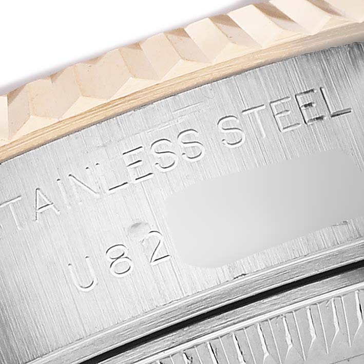The image shows a close-up of the side and outer edge of a Rolex Datejust 69173 Women's Steel and Gold (two tone) White Dial watch, highlighting the engraved text on the stainless steel.