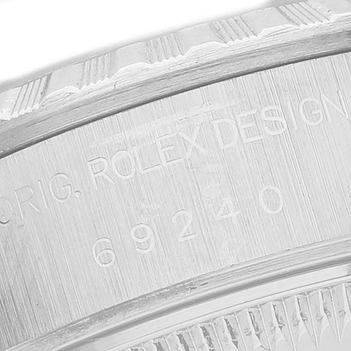 The image shows a close-up of the side engraving and fluted bezel of a Rolex Datejust 69240 Men's Stainless Steel Blue Dial, highlighting the serial number and design details.