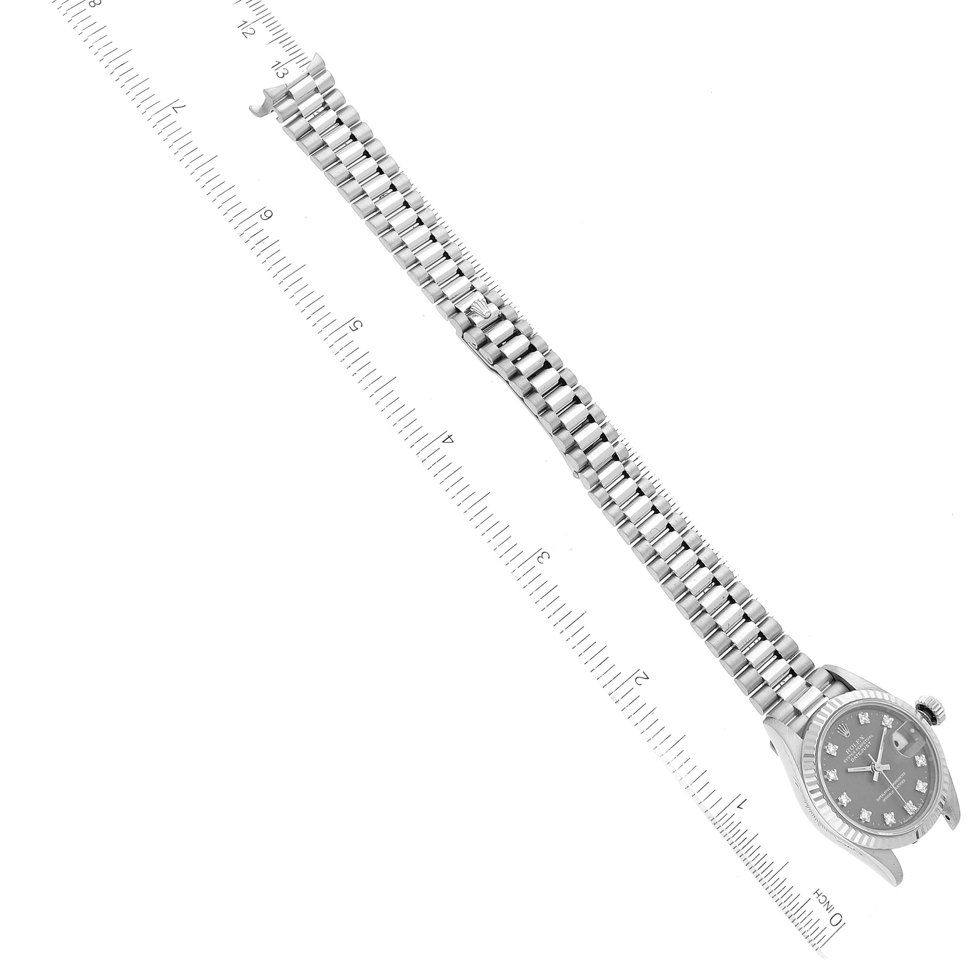 The image shows a Rolex President 69179 Women's White Gold Grey Dial 69179 Women's White Gold Grey Dial watch at a top-down angle, highlighting its bracelet and face next to a ruler for scale.