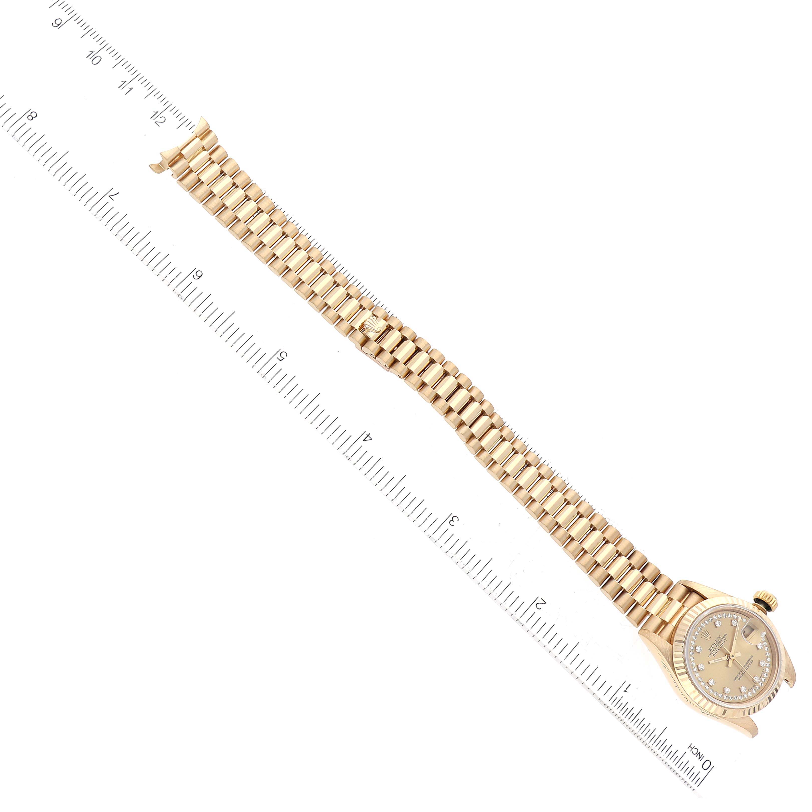 This image shows a horizontal view of a Rolex President 69178 Women
s Yellow Gold Champagne Dial 69178 Women
s Yellow Gold Champagne Dial watch, highlighting the dial, crown, and full gold bracelet with a measuring ruler.