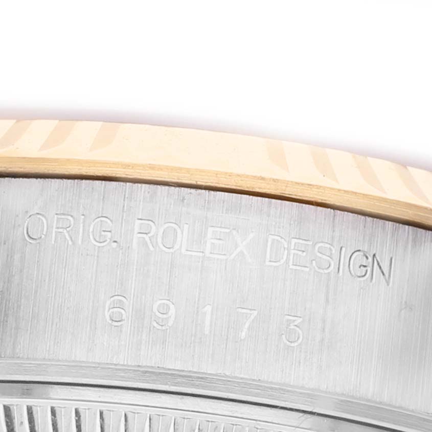 The image shows a close-up of the side of a Rolex Datejust 69173 Women's Steel and Gold (two tone) Black Dial, highlighting the engraving "ORIG. ROLEX DESIGN" with numbers.