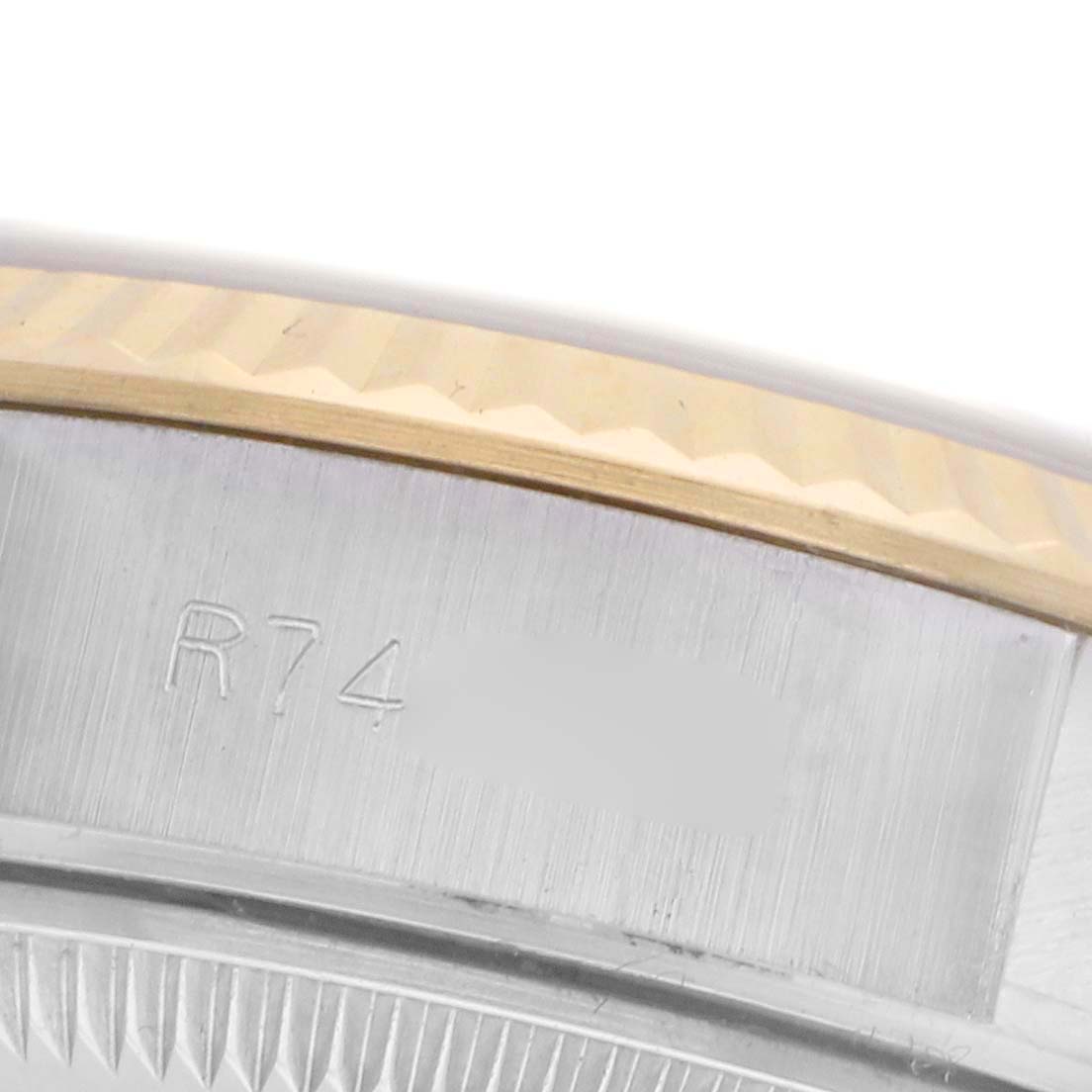 The image shows a close-up of the Rolex Datejust 69173 Women's Steel and Gold (two tone) Champagne Dial 69173 Women's Steel and Gold (two tone) Champagne Dial watch bezel and case, featuring a fluted design and engraved details.