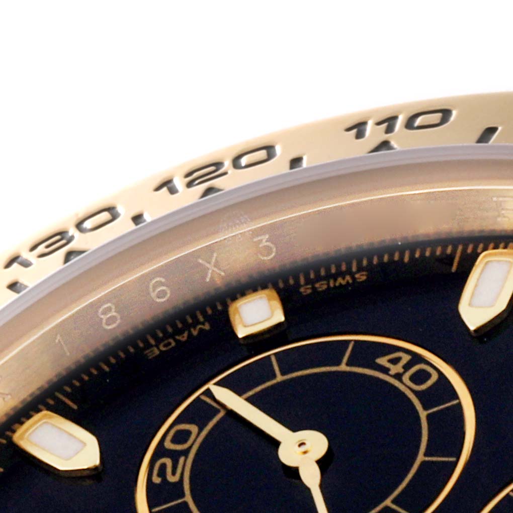 This close-up image shows part of the bezel and dial of a Rolex Daytona M116518-0080 Men's Yellow Gold Black Dial M116518-0080 Men's Yellow Gold Black Dial watch.
