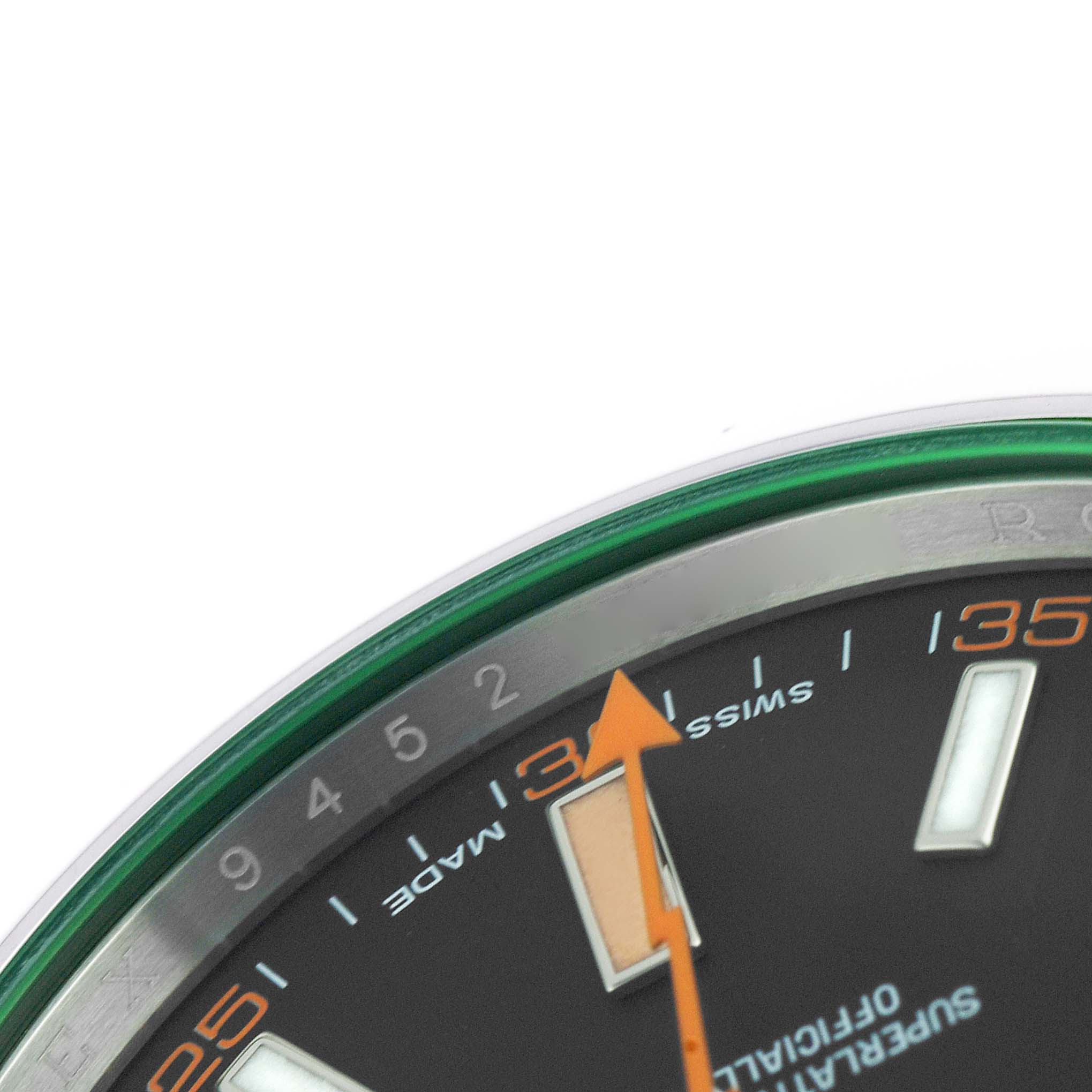 The image shows a close-up of the dial and bezel of a Rolex Milgauss M116400GV-0001 Men's Stainless Steel Black Dial, highlighting the minute markers and orange second hand.