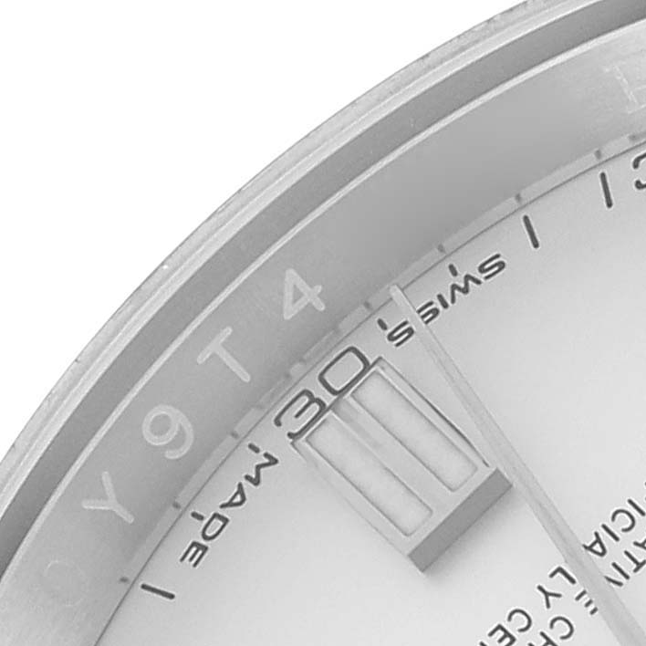 The image shows a close-up of the dial and part of the bezel of a Rolex Oyster Perpetual 116000 Men's Stainless Steel Silver Dial 116000 Men's Stainless Steel Silver Dial watch.
