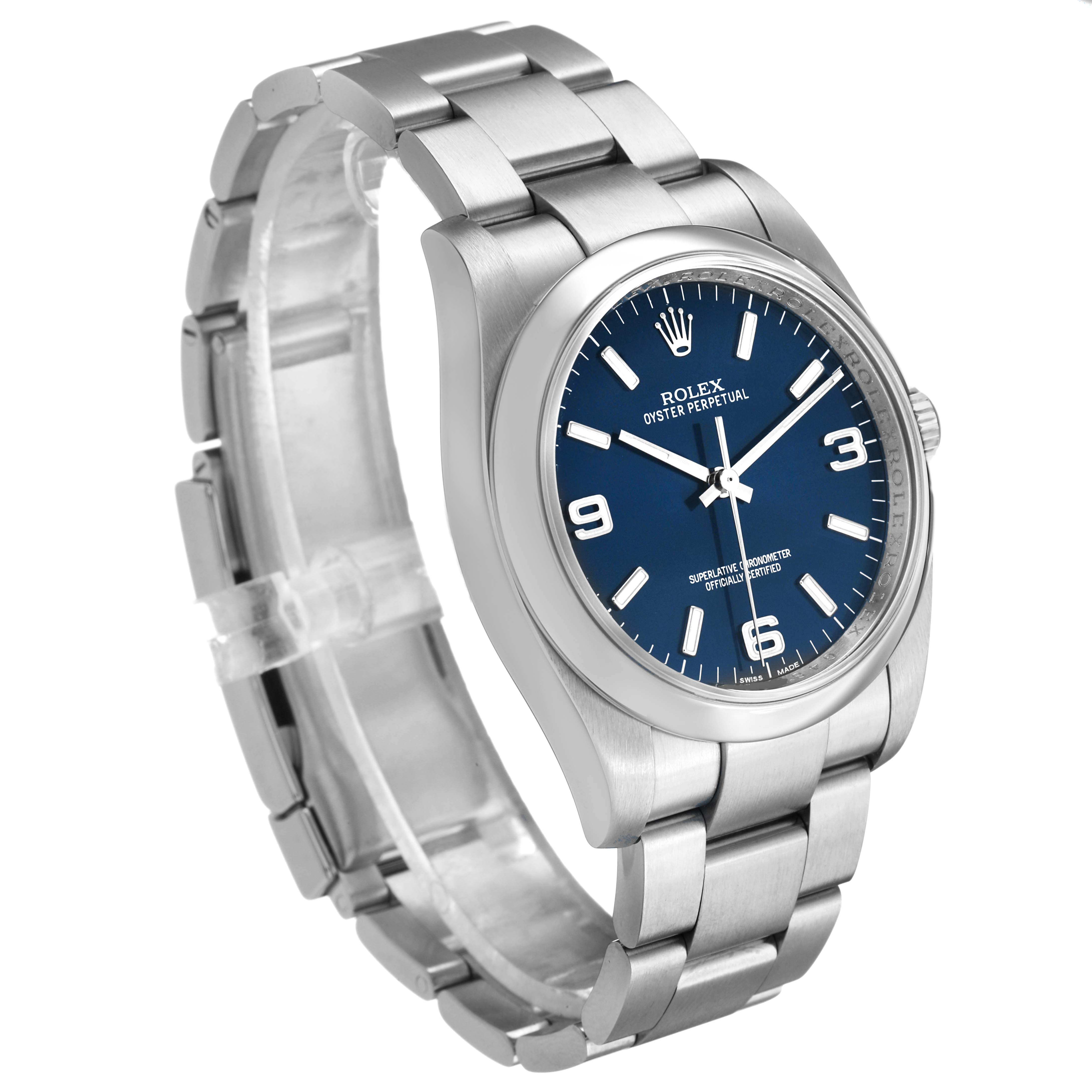 The Rolex Oyster Perpetual 116000 Men's Stainless Steel Blue Dial watch is shown at an oblique angle, displaying the bracelet, case, and blue dial fully.