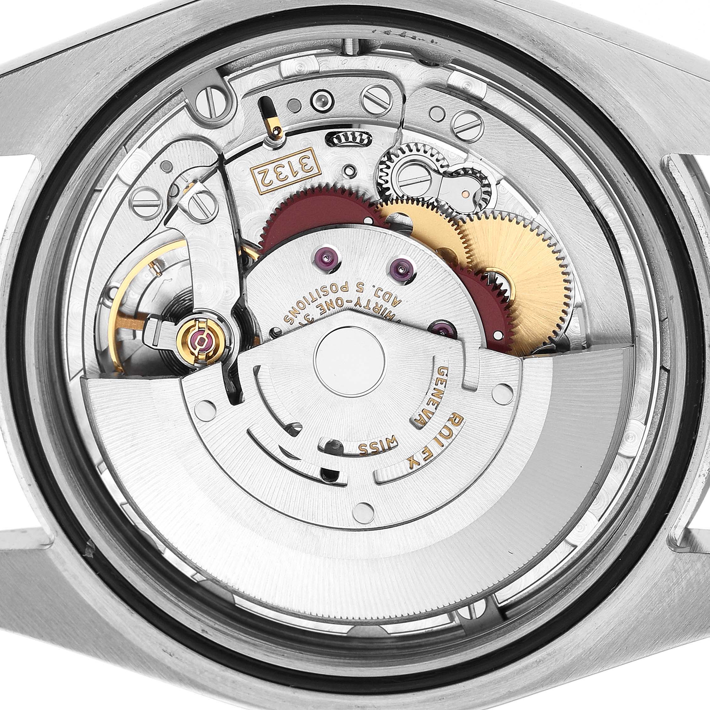 The image shows the movement of a Rolex Oyster Perpetual 114300 Men's Stainless Steel Blue Dial watch from the back, highlighting gears and rotors.