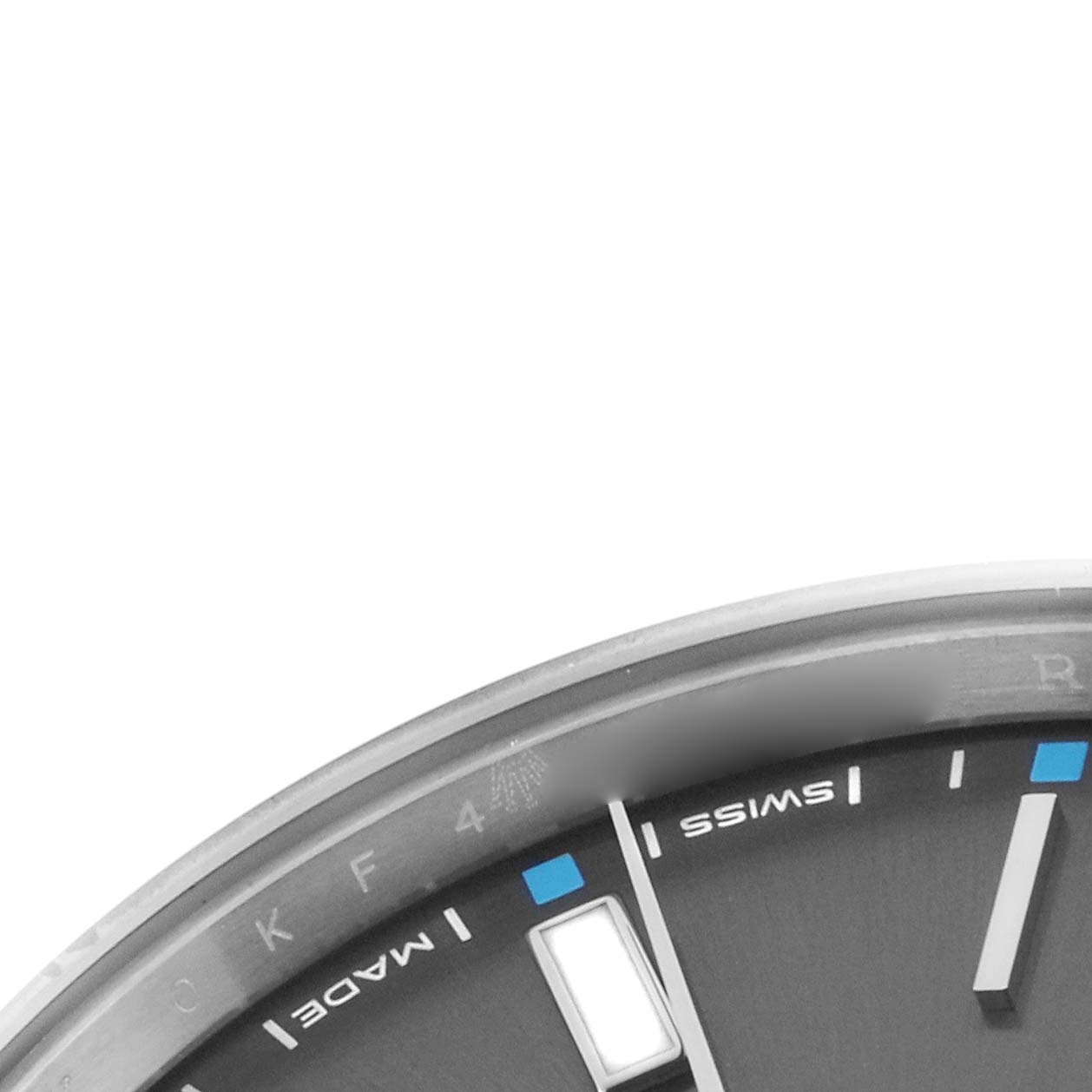 The image shows a close-up of the Rolex Oyster Perpetual 114300 Men's Stainless Steel Grey Dial 114300 Men's Stainless Steel Grey Dial watch face, highlighting the hour markers and the "SWISS MADE" text.