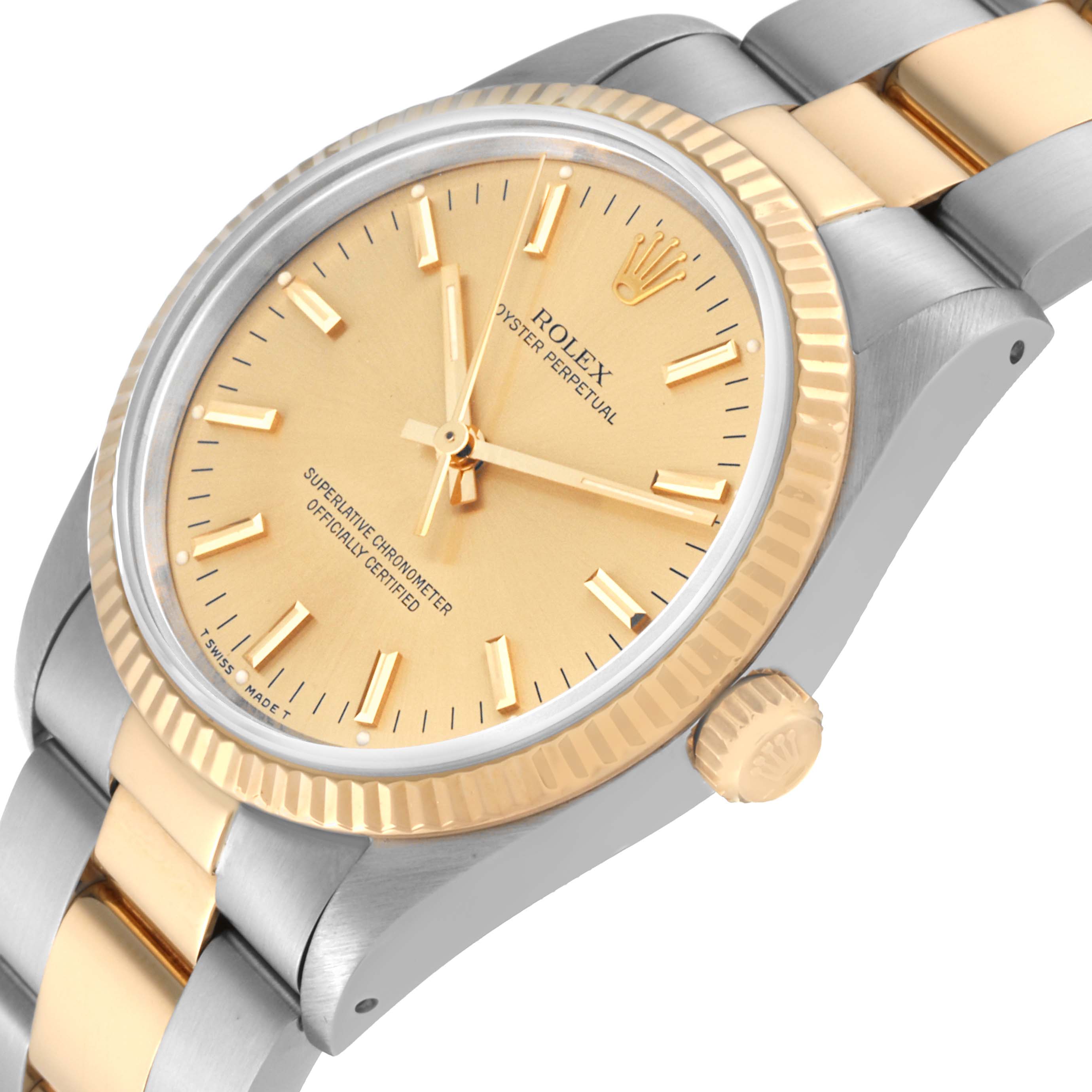 This image shows the face, bezel, crown, and part of the bracelet of a Rolex Oyster Perpetual 14233 Men's Steel and Gold (two tone) Champagne Dial 14233 Men's Steel and Gold (two tone) Champagne Dial watch from an angled perspective.