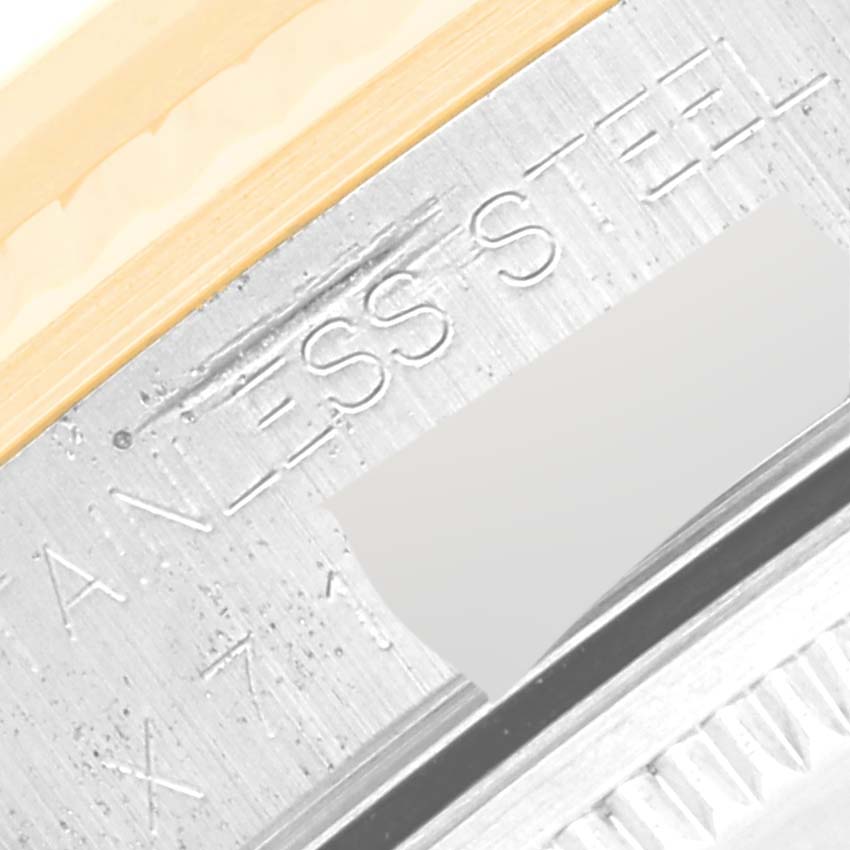 The image shows a close-up of the edge and side lettering on a Rolex Oyster Perpetual 14233 Men's Steel and Gold (two tone) Champagne Dial 14233 Men's Steel and Gold (two tone) Champagne Dial watch, highlighting the stainless steel composition.