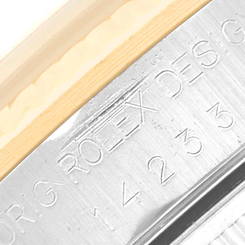 This image shows a close-up of the engraved bezel of the Rolex Oyster Perpetual 14233 Men's Steel and Gold (two tone) Champagne Dial 14233 Men's Steel and Gold (two tone) Champagne Dial watch, including part of the model and serial number.