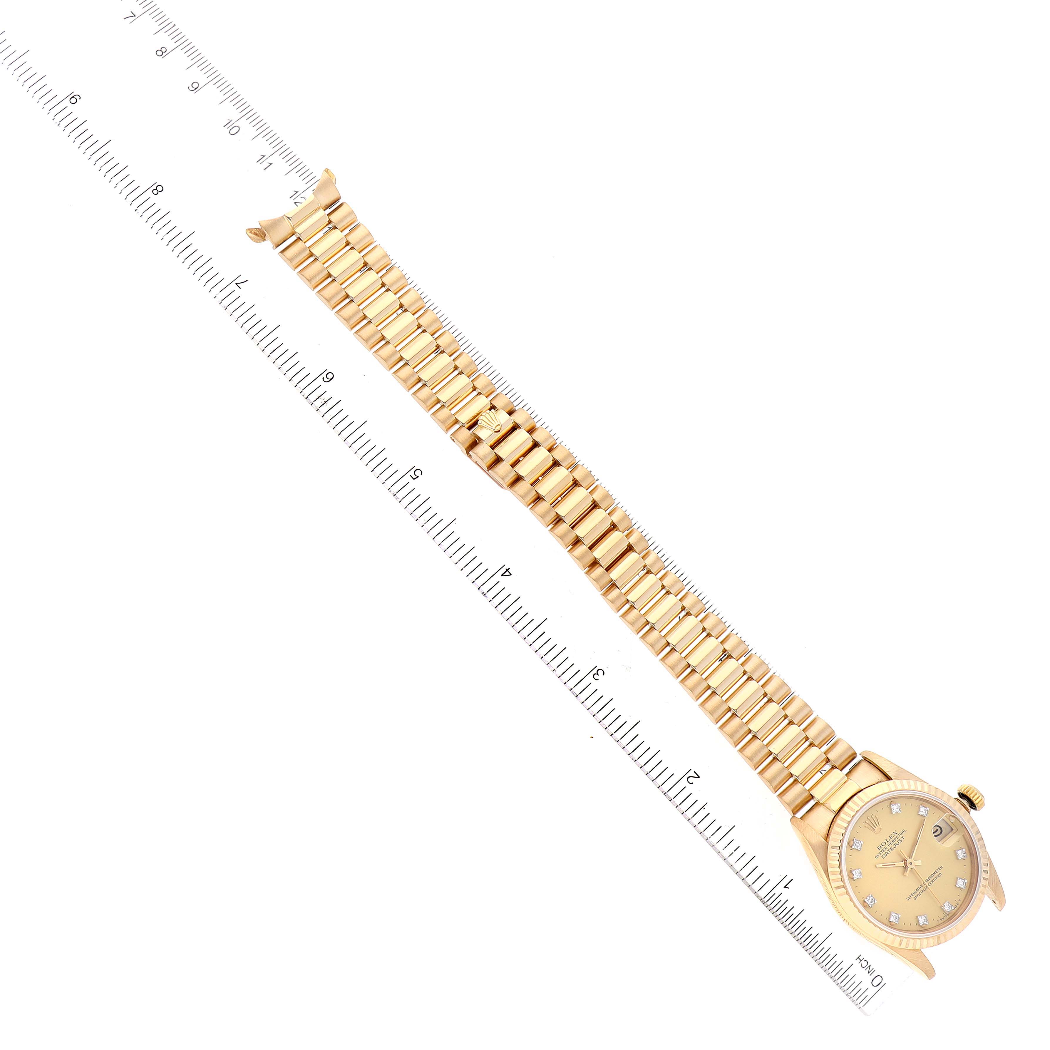 The image shows a top-down view of a Rolex President 68278 Women
s Yellow Gold Champagne Dial 68278 Women
s Yellow Gold Champagne Dial model watch with its face, band, and crown visible, next to a ruler for size reference.